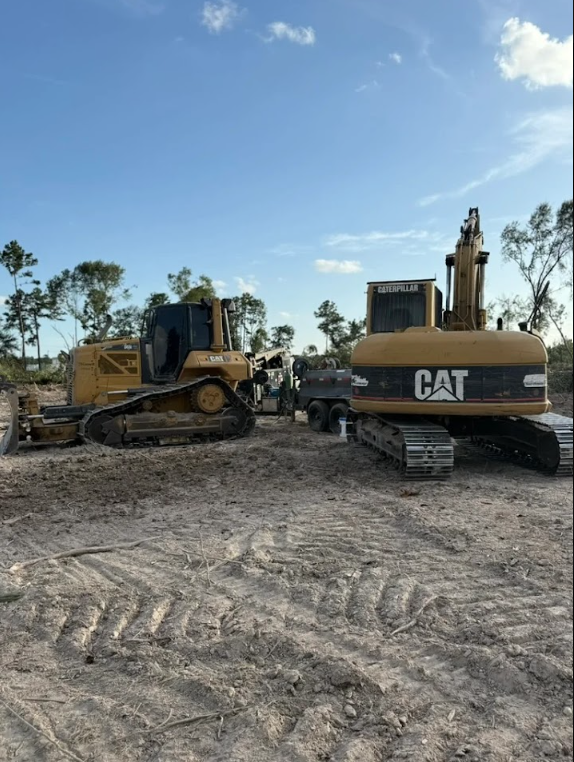 Heavy equipment and tools on a job site, showcasing the machinery and materials used for land clearing and construction work.