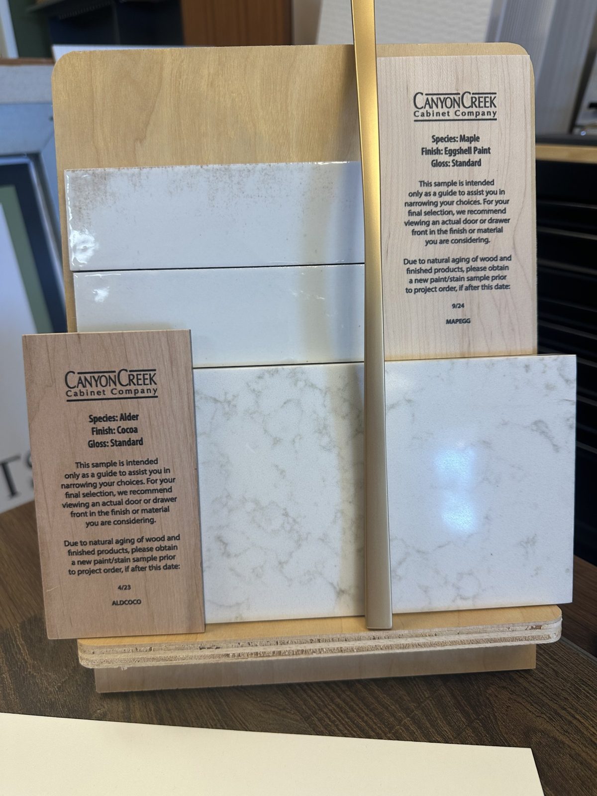 Cabinet door, quartz and tile samples laid out for material selection