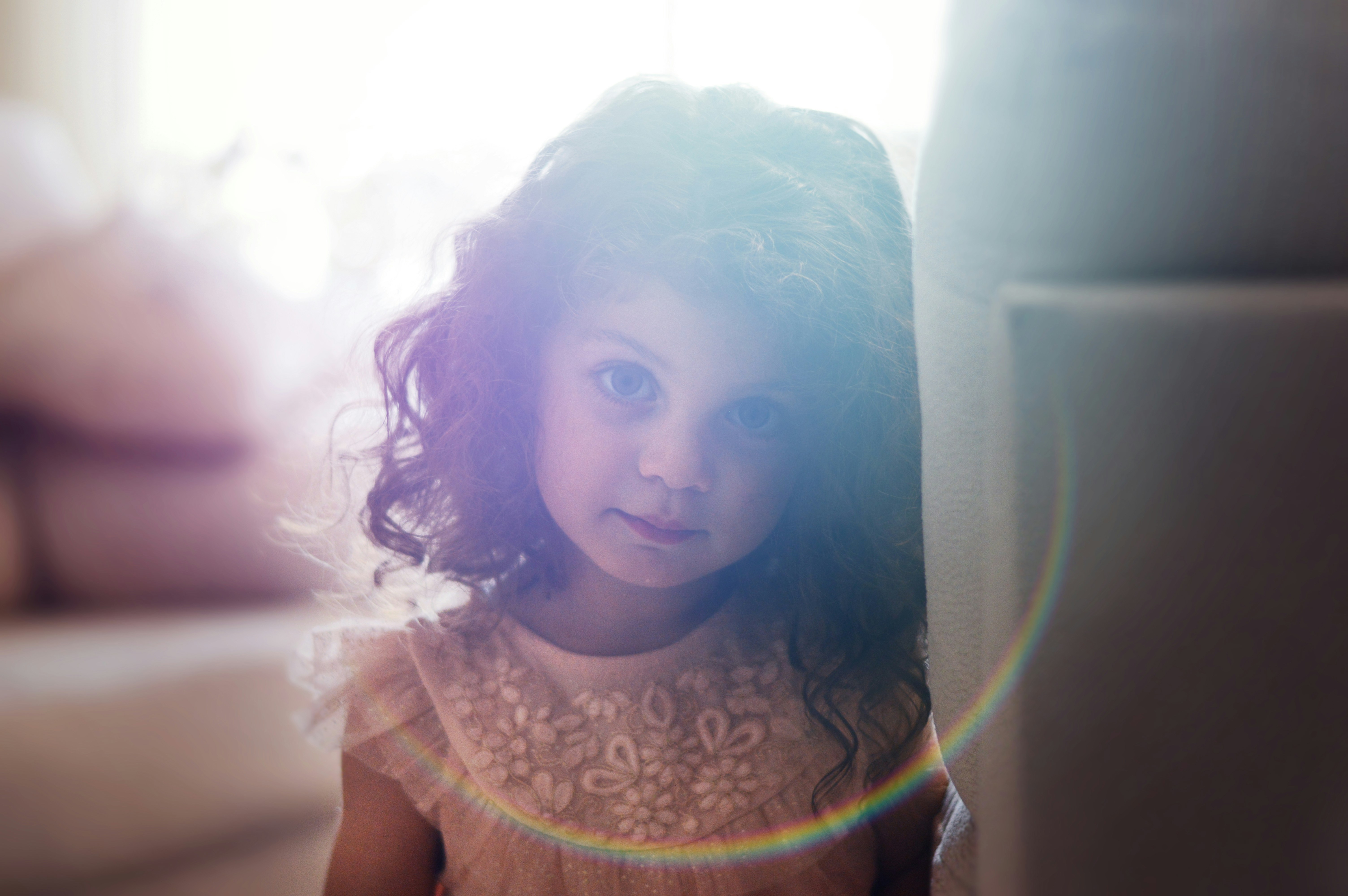 child looks toward camera through lens flare