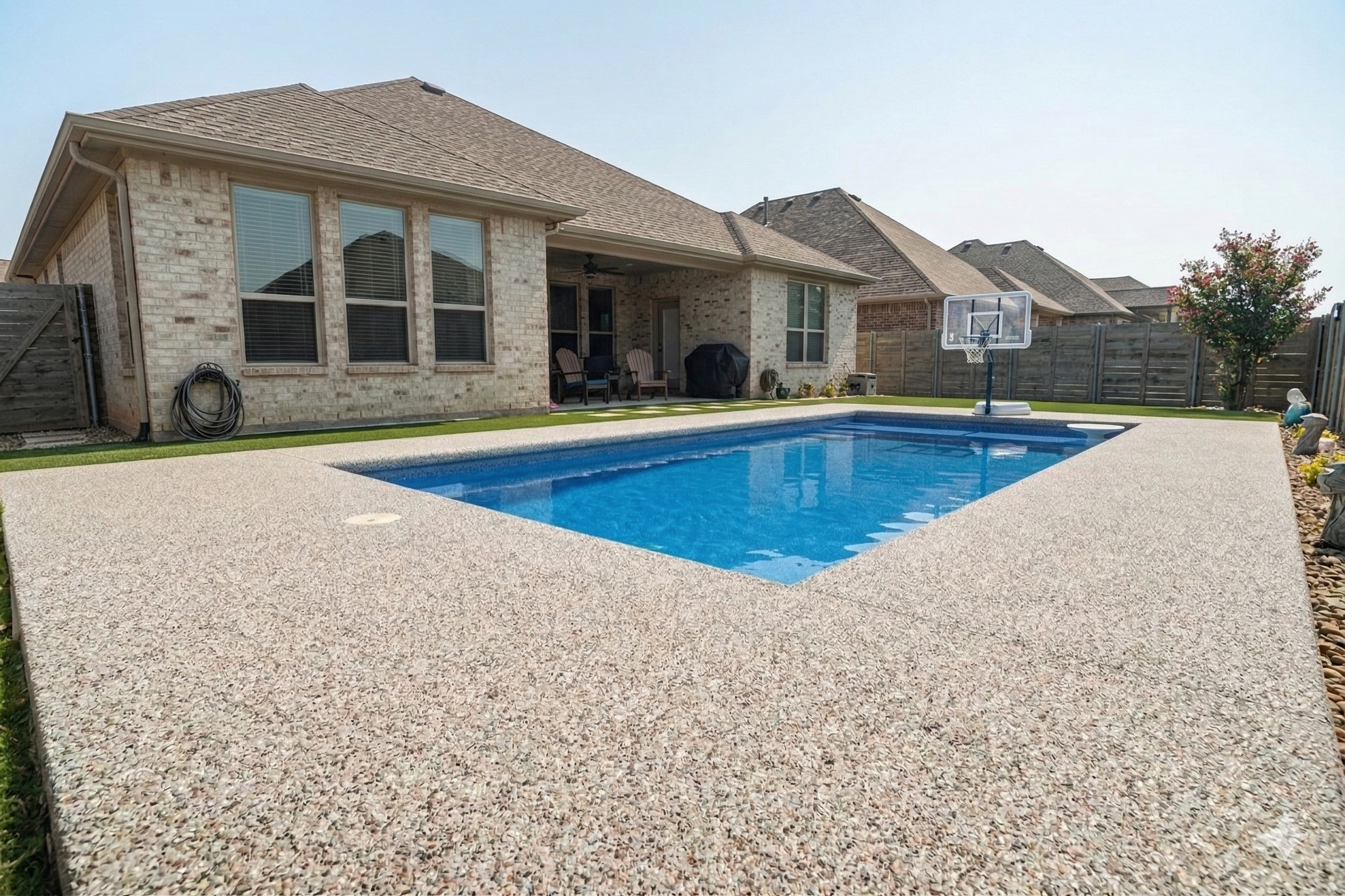 Custom charcoal gray premium TPV rubber pool decking installed in a luxury Dallas neighborhood backyard