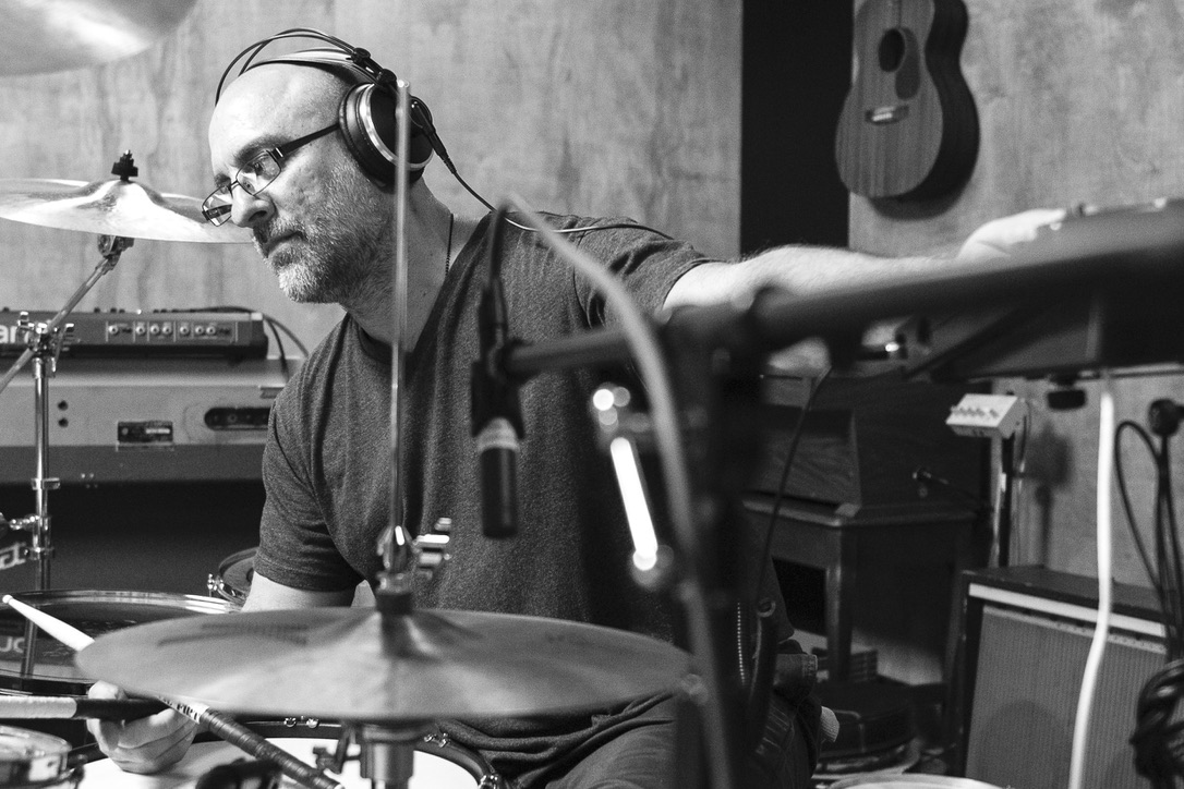 Tim Alexander at the drum kit making adjustments during a studio session Tim Alexander at the drum kit making adjustments during a studio session