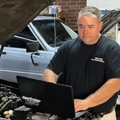 A Helms Automotive technician running diagnostics on a laptop in the Greensboro shop (Photo: Helms Automotive Service website)