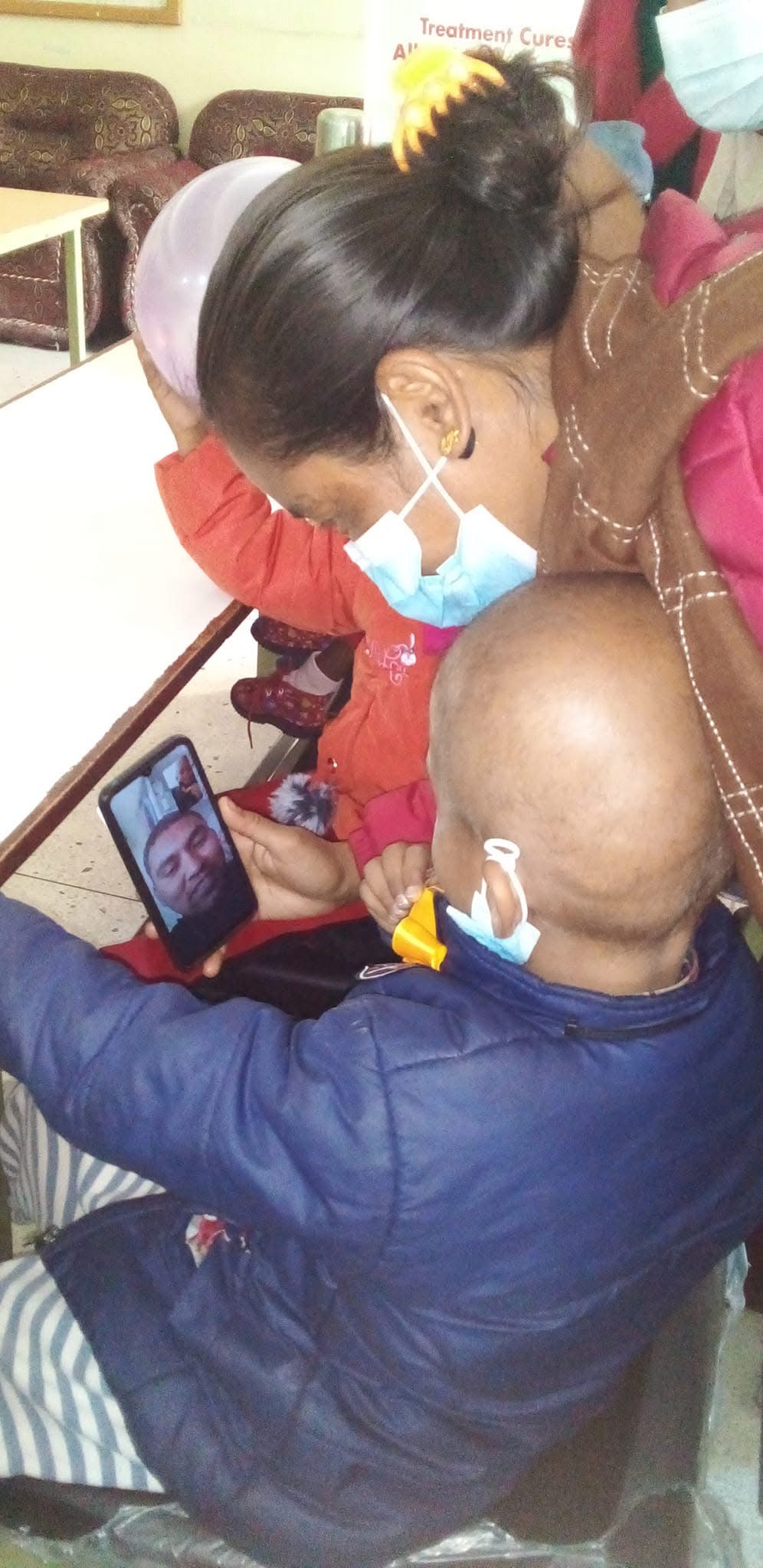 A young child connects with a parent during cancer treatment