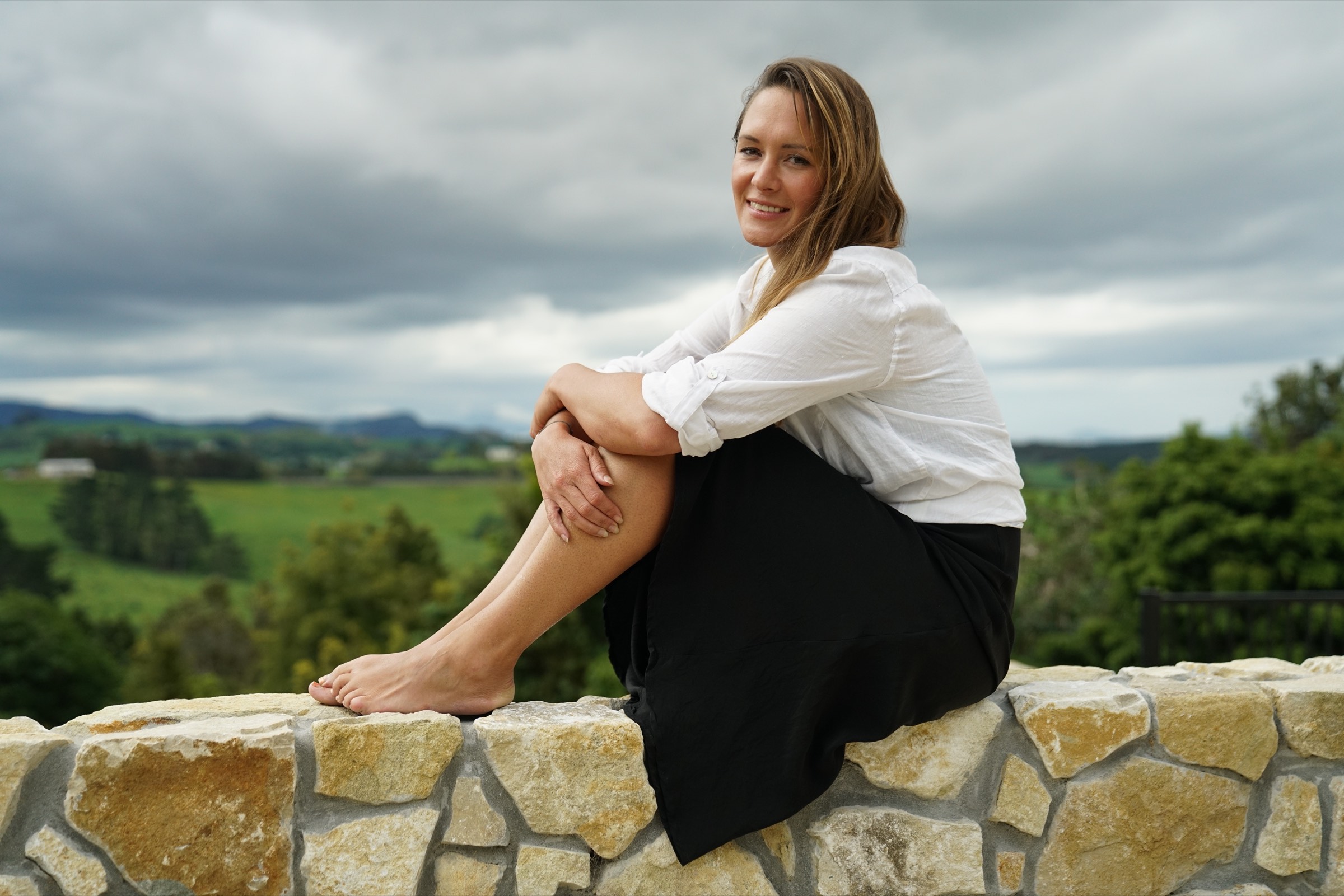 Fleur Lonsdale, miscarriage and pregnancy loss coach, sitting outdoors under an overcast sky
