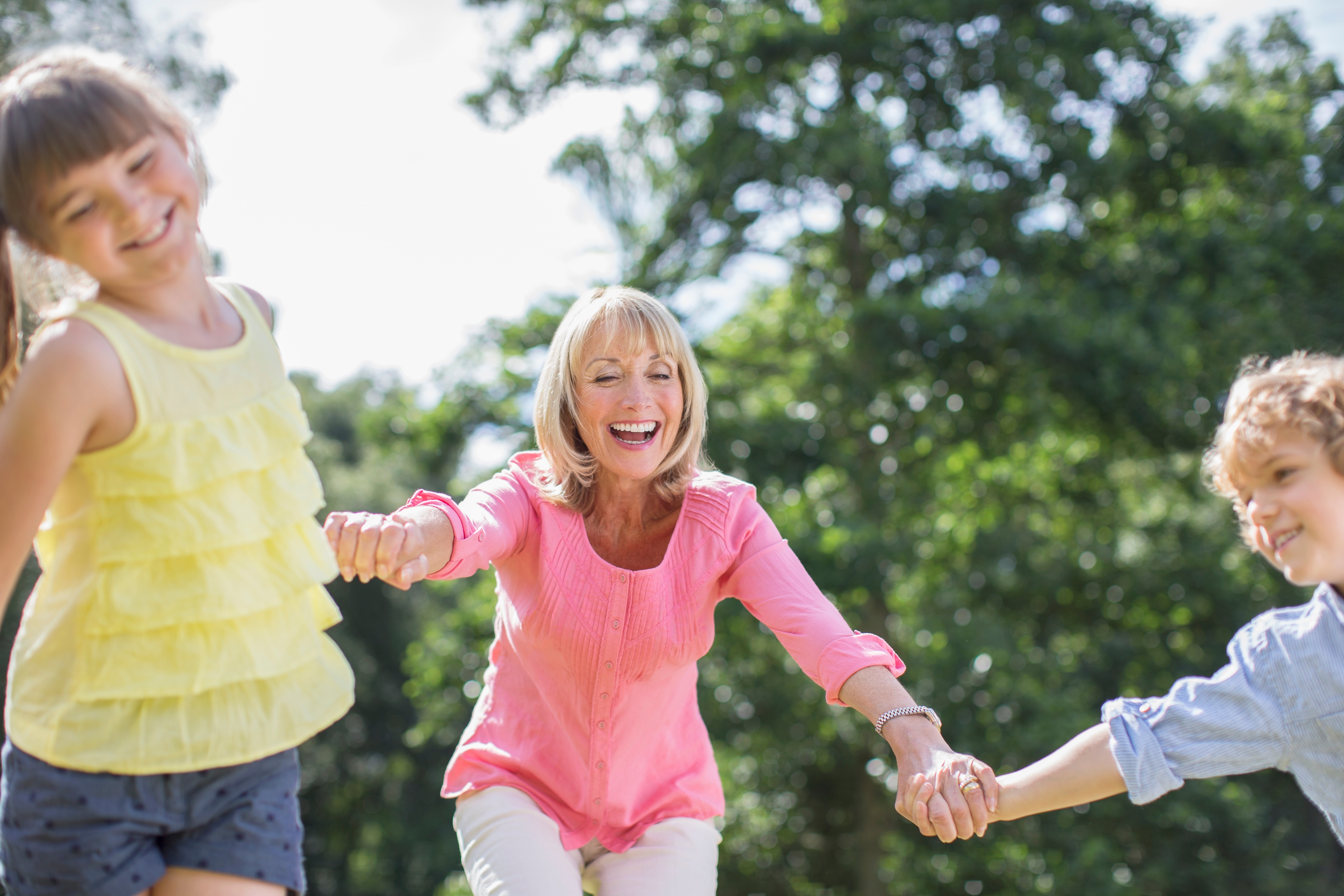 Grandmother playing outdoors with grandchildren