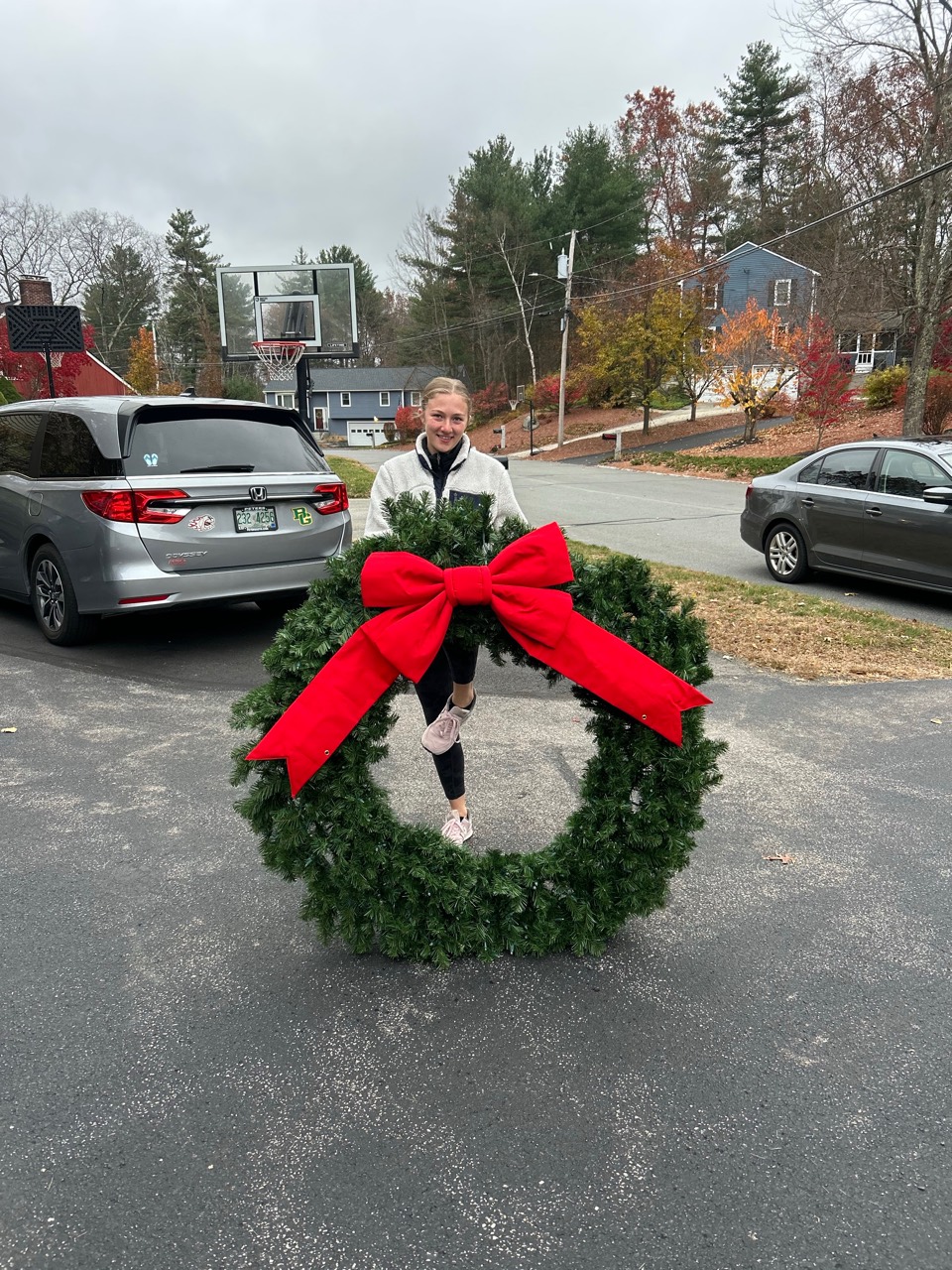 Large green holiday wreath with a red bow prepared for installation