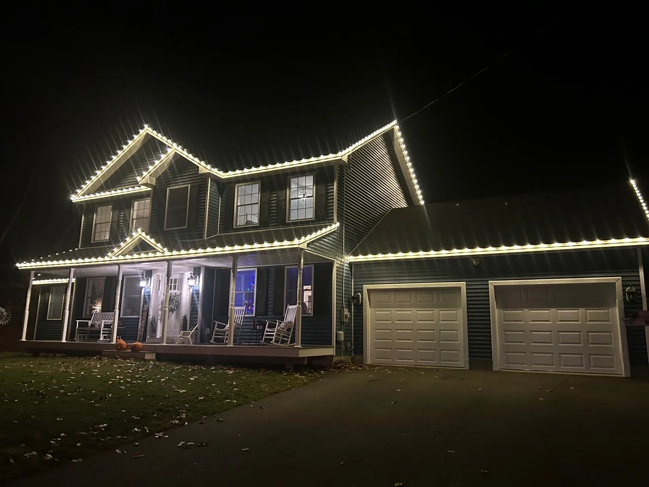 Completed Peak Lights warm-white roofline lighting on the same blue home