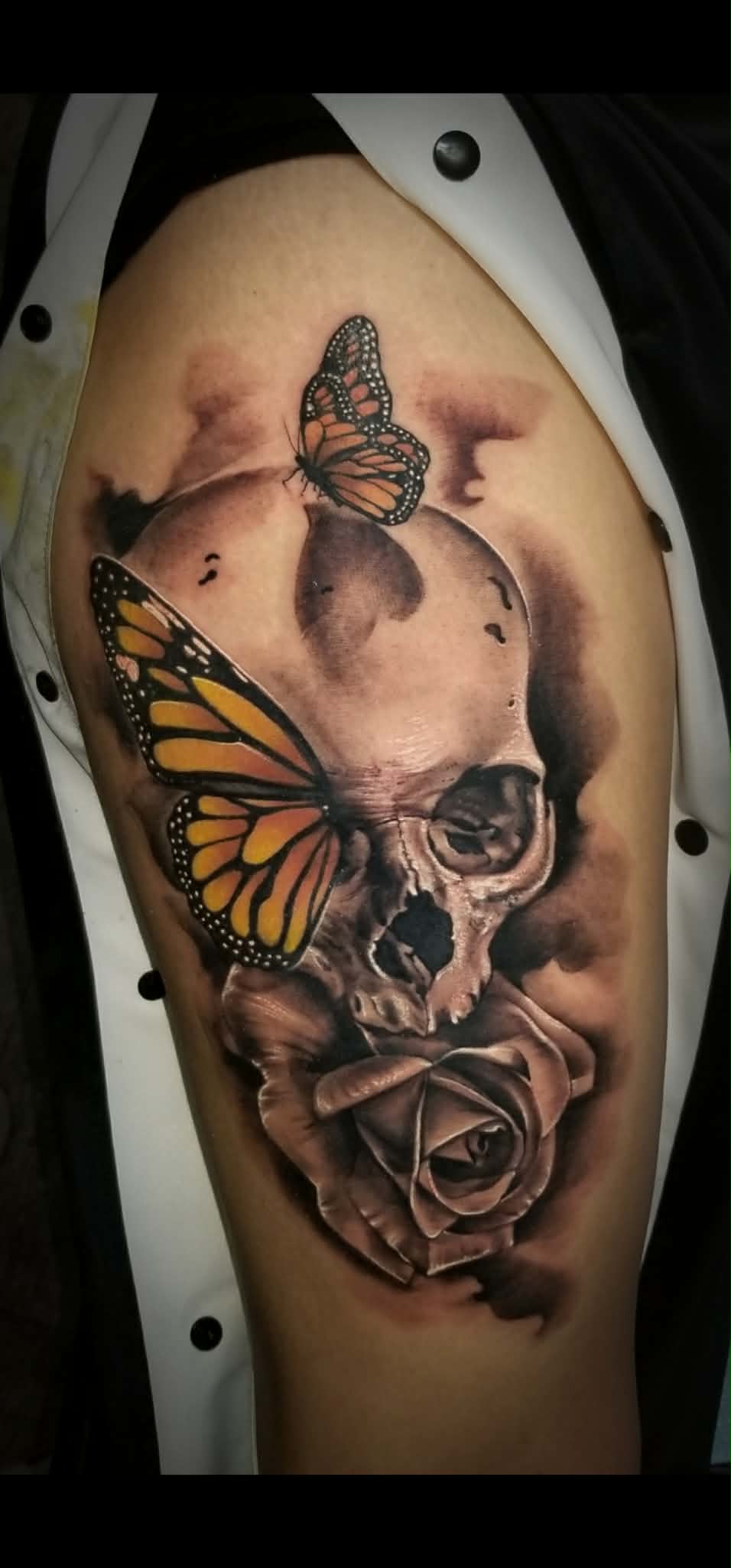 Black and grey skull, butterfly, and rose tattoo
