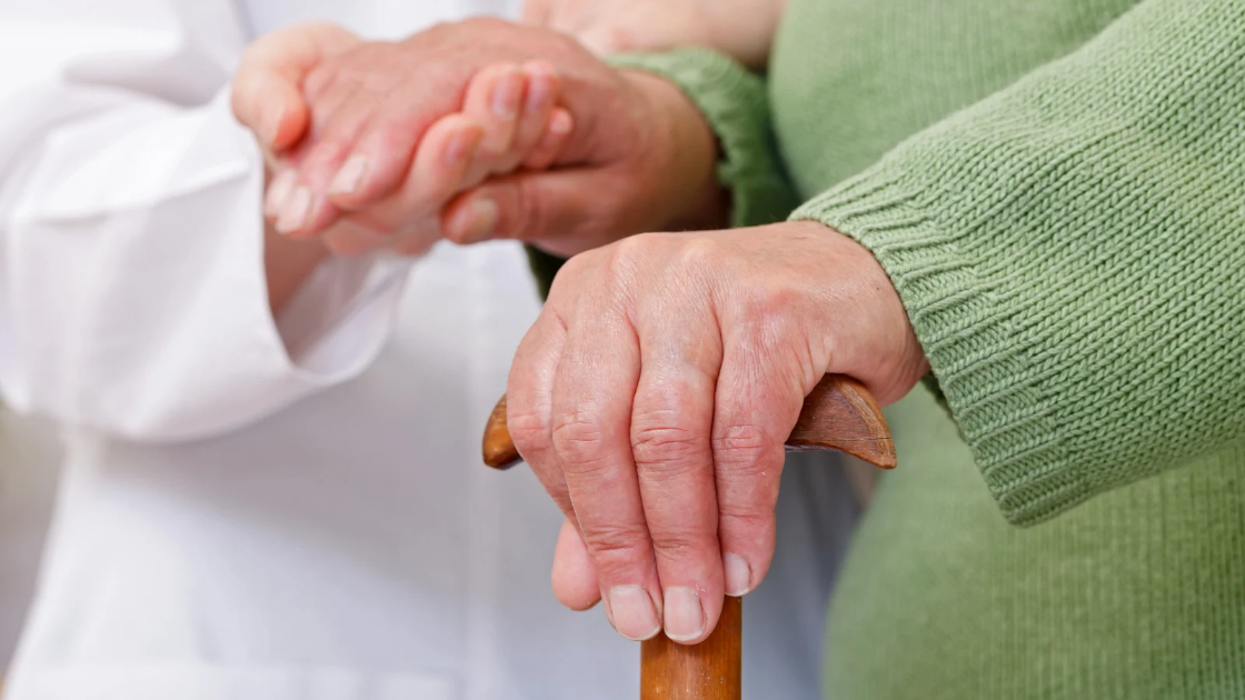 Doctor holding the hands of an elderly patient