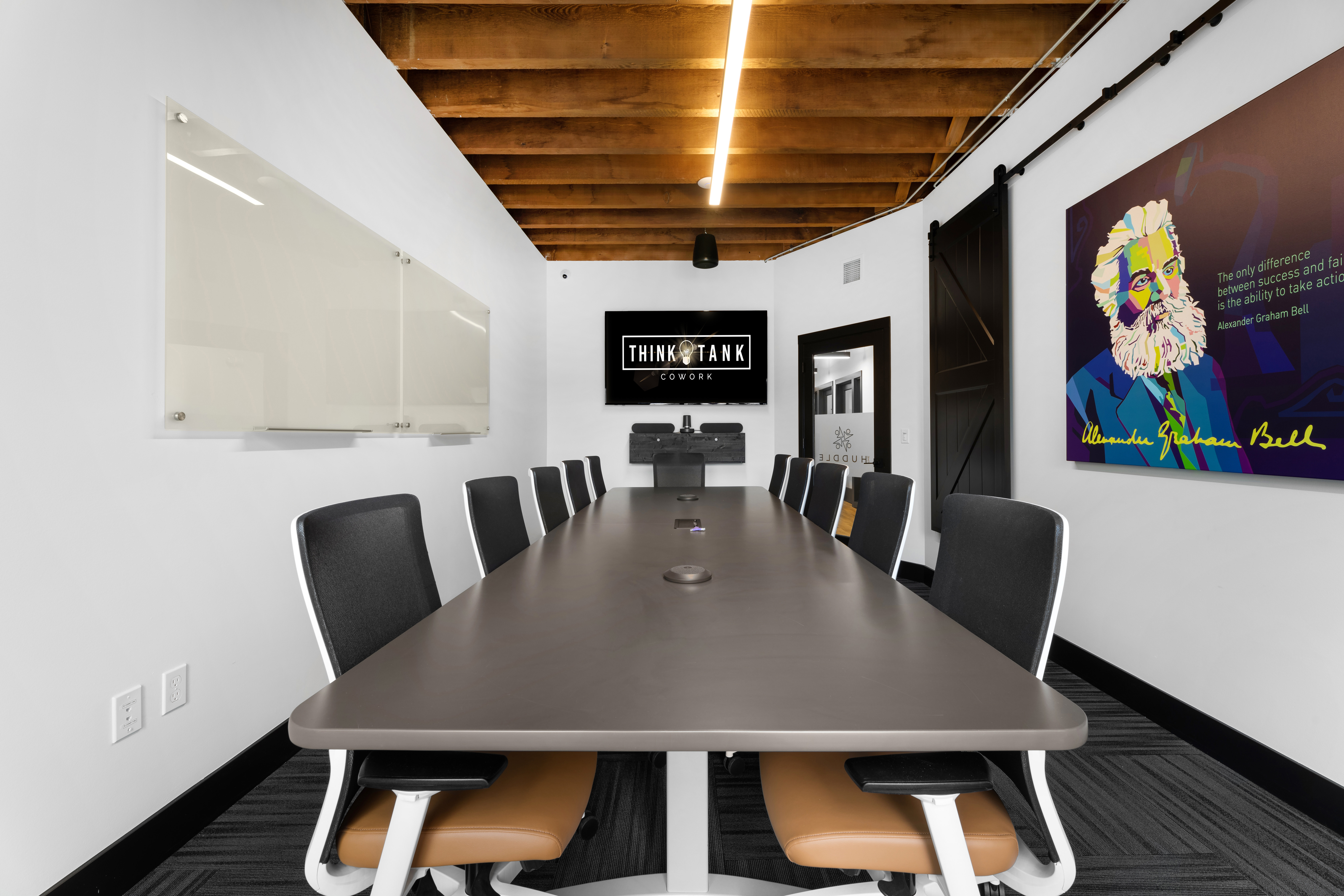 The Huddle, a meeting room seating twelve with a display and whiteboard, at Think Tank Cowork in downtown Everett, Washington