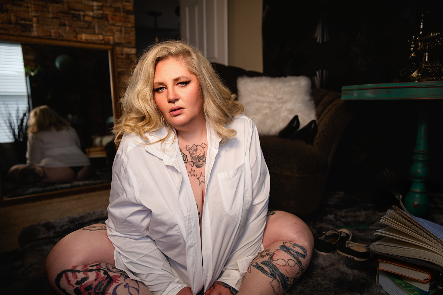 A blonde woman poses in a button-down shirt for a boudoir shoot in Indianapolis at Enchanted Moments Artistry.