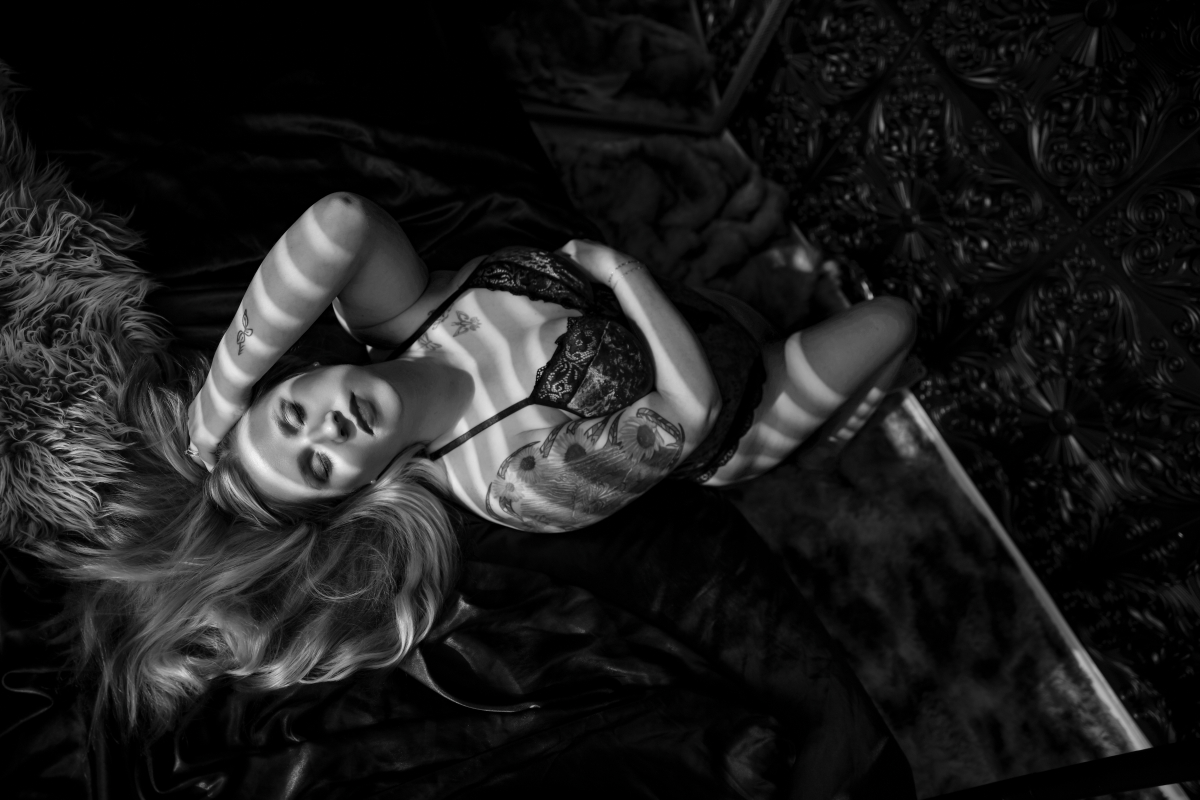 A black and white photo of a woman in lingerie posing for a boudoir shoot in Indianapolis at Enchanted Moments Artistry A black and white photo of a woman in lingerie posing for a boudoir shoot in Indianapolis at Enchanted Moments Artistry
