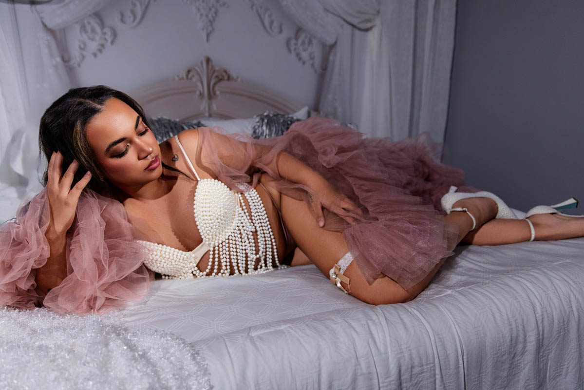 A woman in white beaded lingerie poses for a boudoir shoot in Indianapolis at Enchanted Moments Artistry A woman in white beaded lingerie poses for a boudoir shoot in Indianapolis at Enchanted Moments Artistry