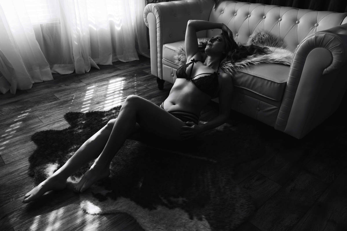 A woman in lingerie poses for a black-and-white boudoir shoot in Indianapolis at Enchanted Moments Artistry