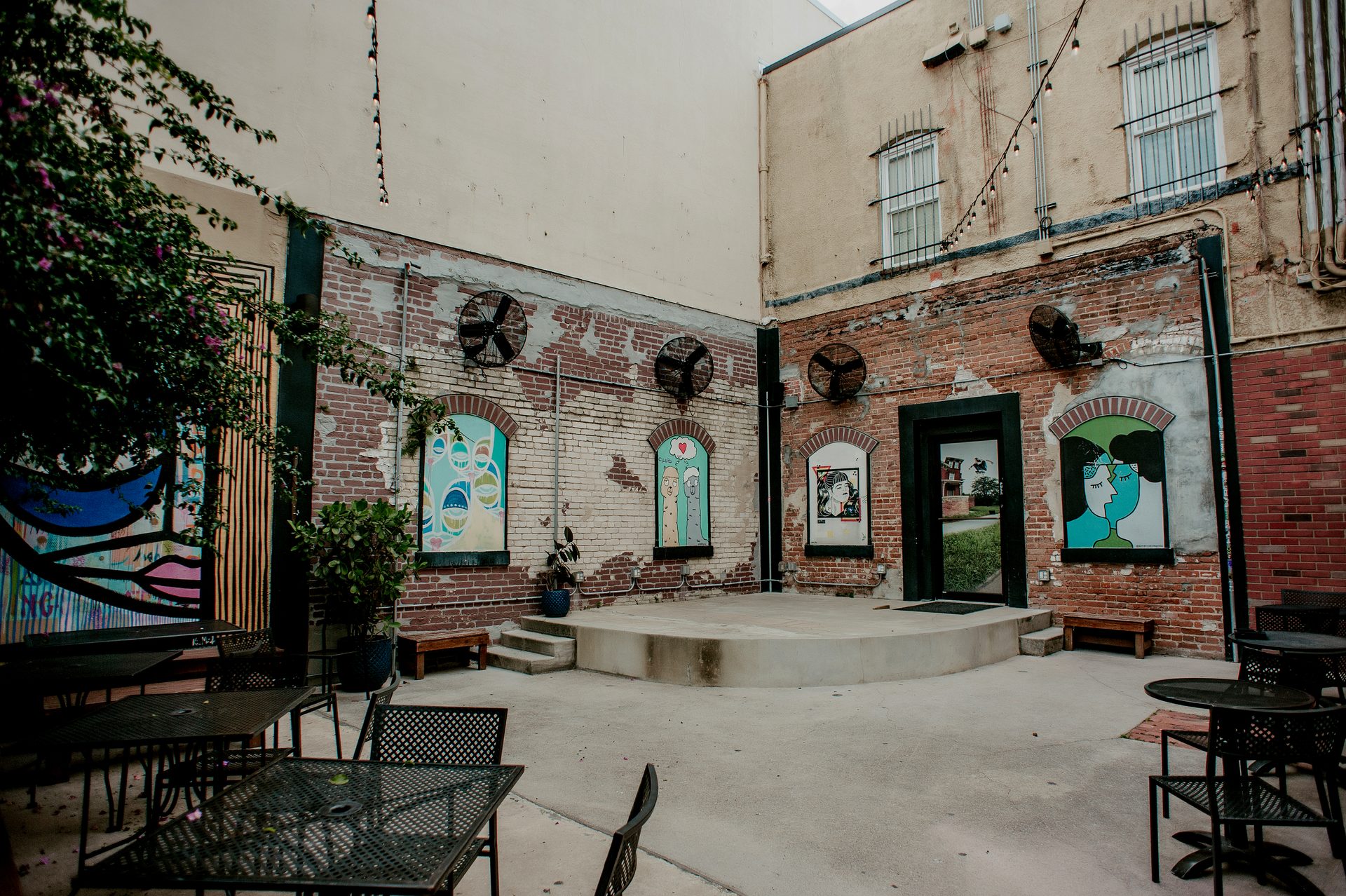 The Bricks courtyard stage with murals and string lights