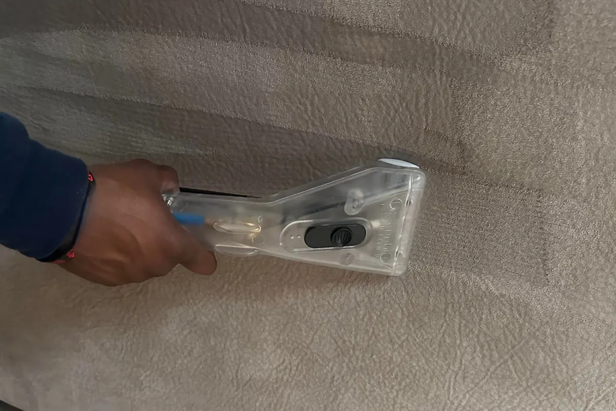 Close-up of professional upholstery steam cleaning extracting dirt from a fabric chair