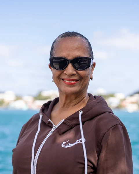 Amatullah, INTO Bermuda driver, smiling by the harbour