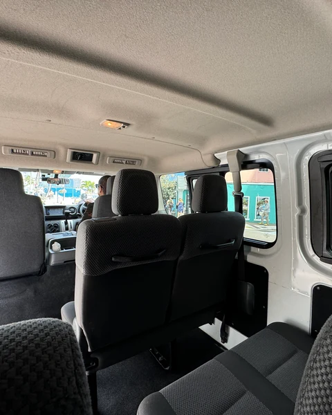 The minibus cabin from the back row, looking forward over the seats