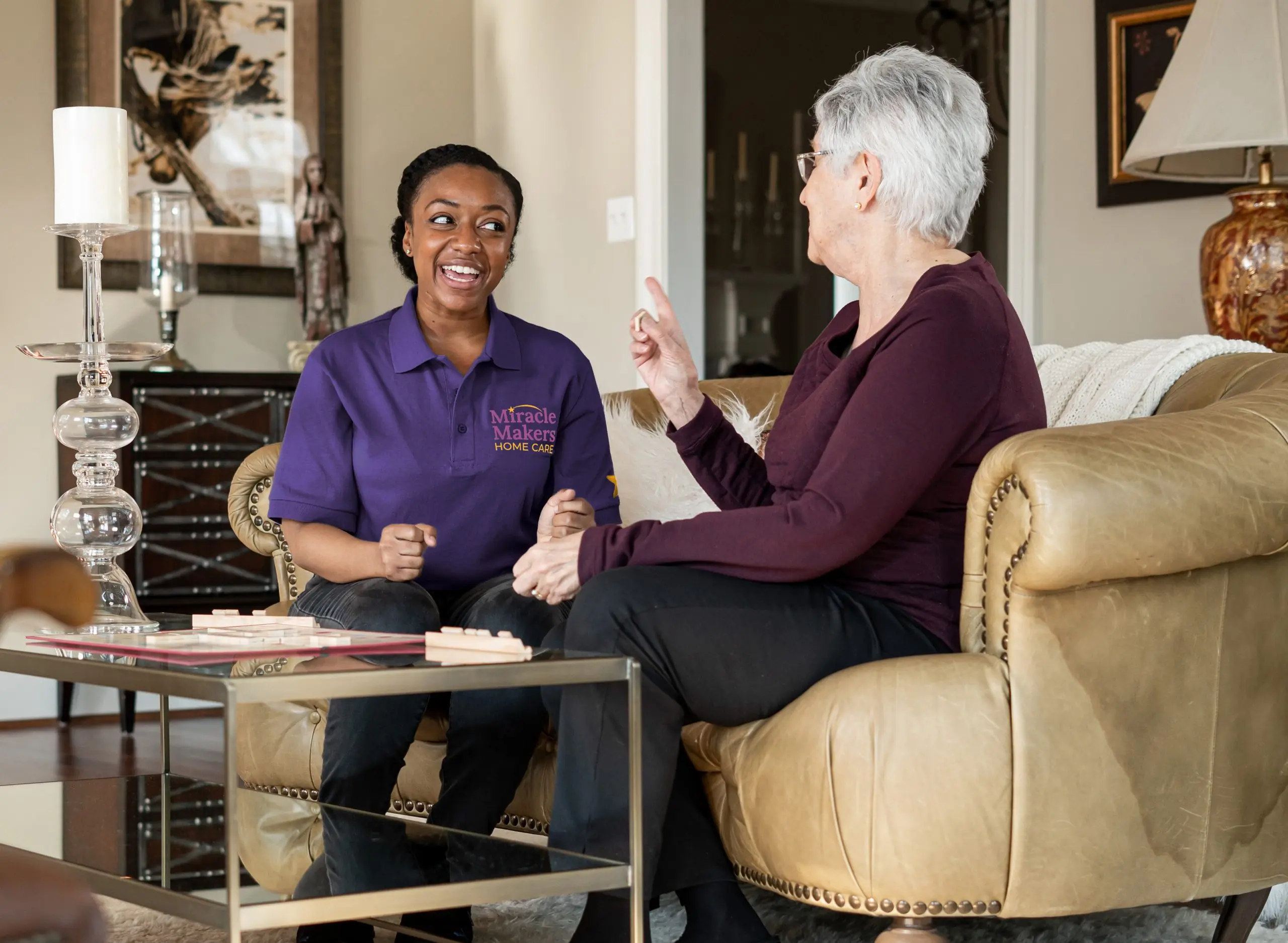 Companion caregiver enjoying conversation and activities with an elderly woman