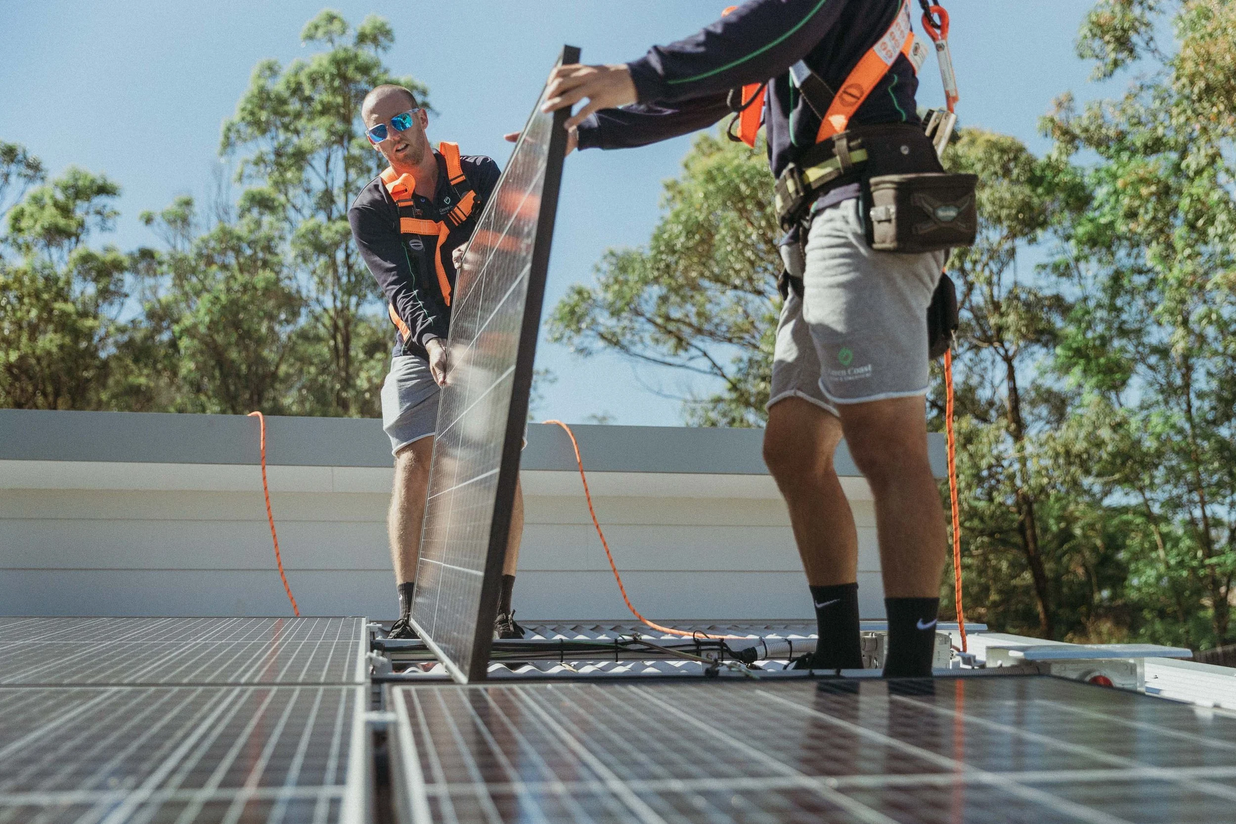 Green Coast's own installers working together on a rooftop