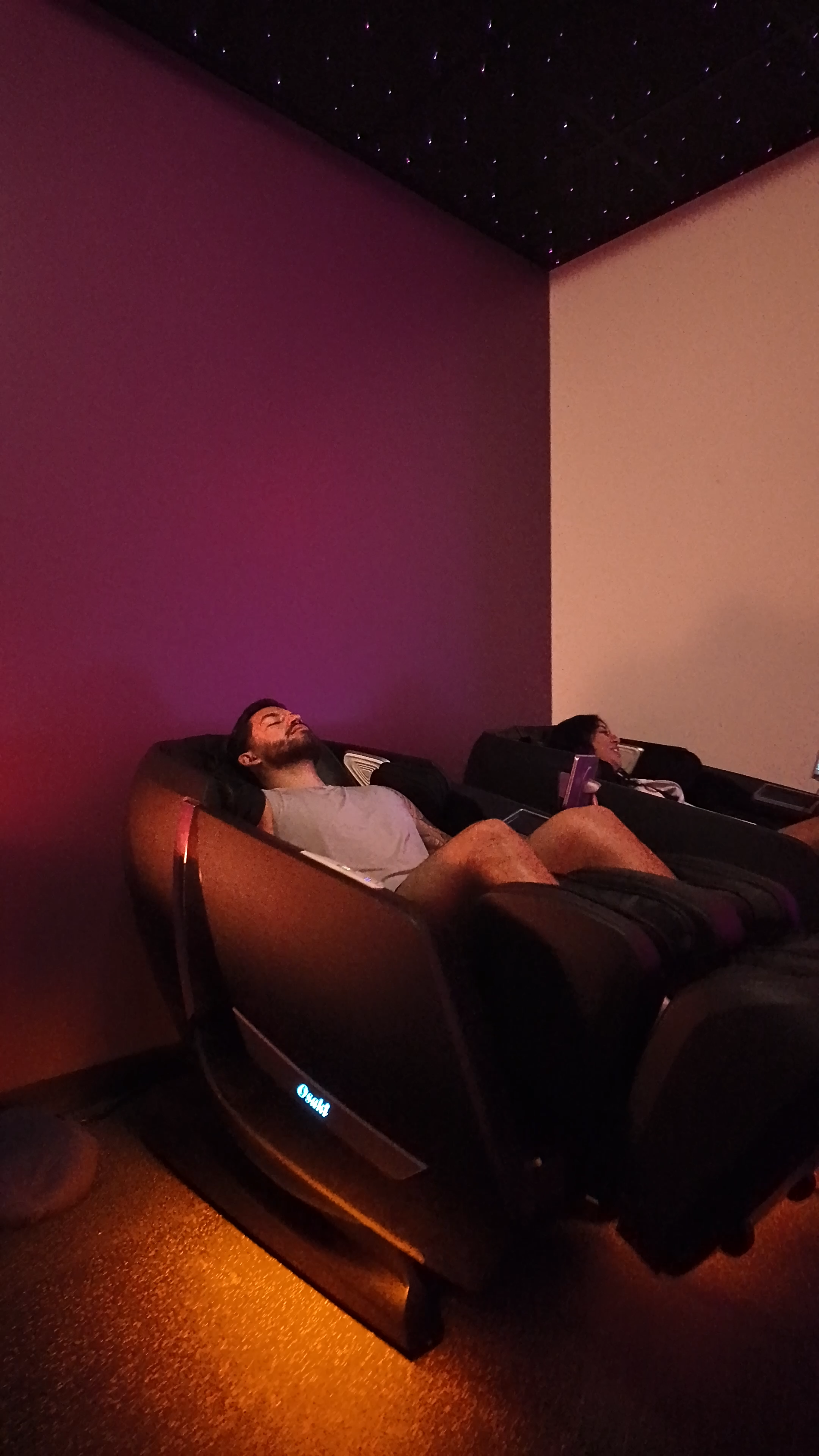 BrainTap massage chairs lounge with multiple chairs and ambient lighting at Evolve