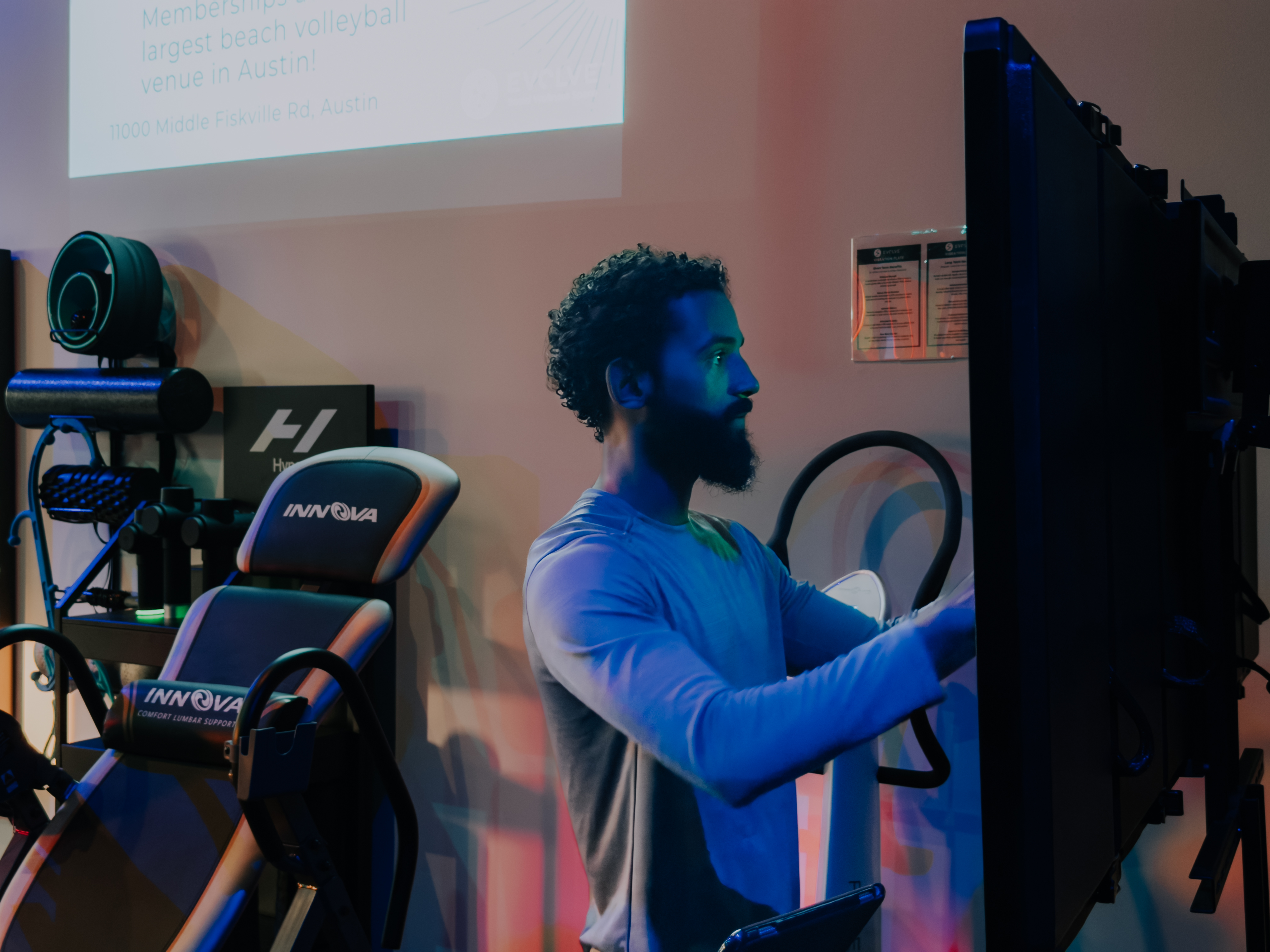 Man using vibration platform and inversion table at Evolve