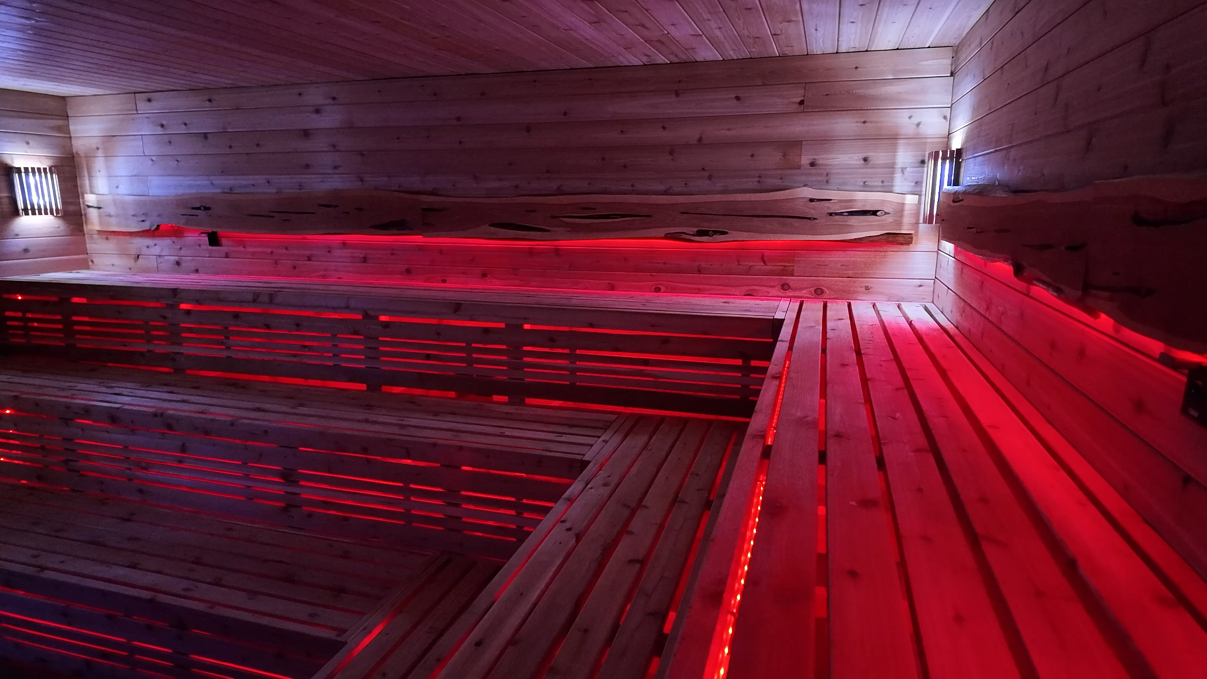 Infrared sauna benches with red glow at Evolve Round Rock