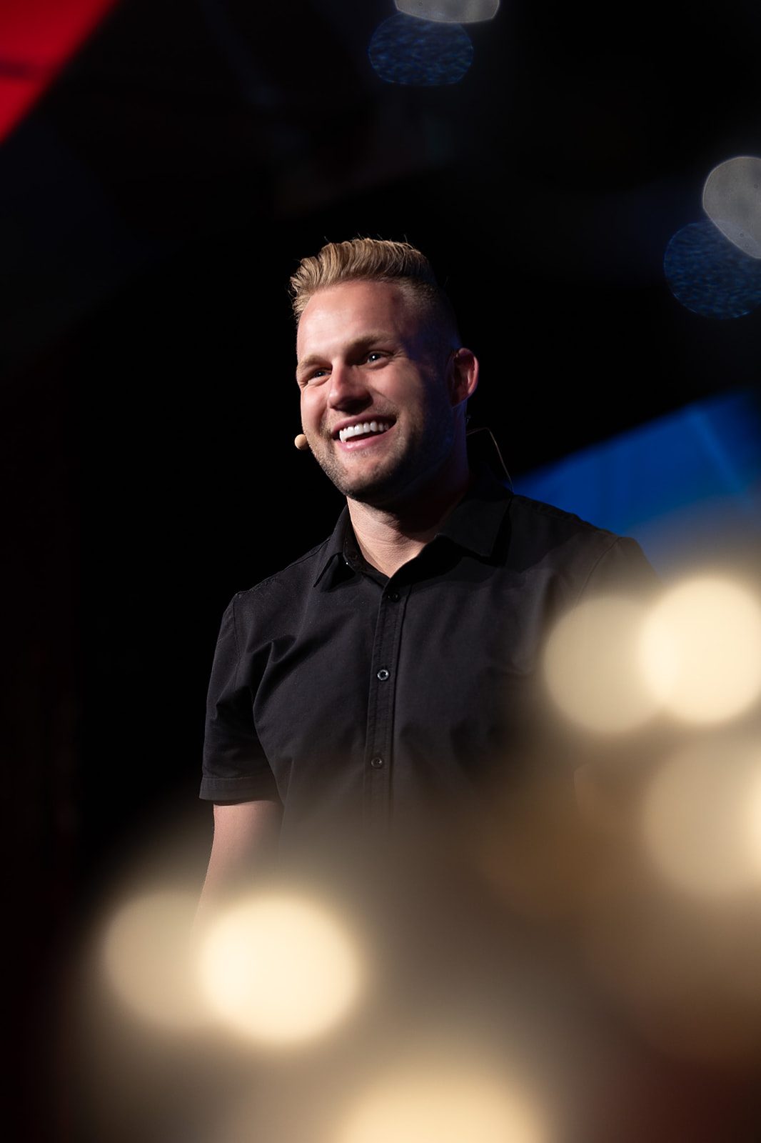 Blake Erickson smiling on stage in warm light