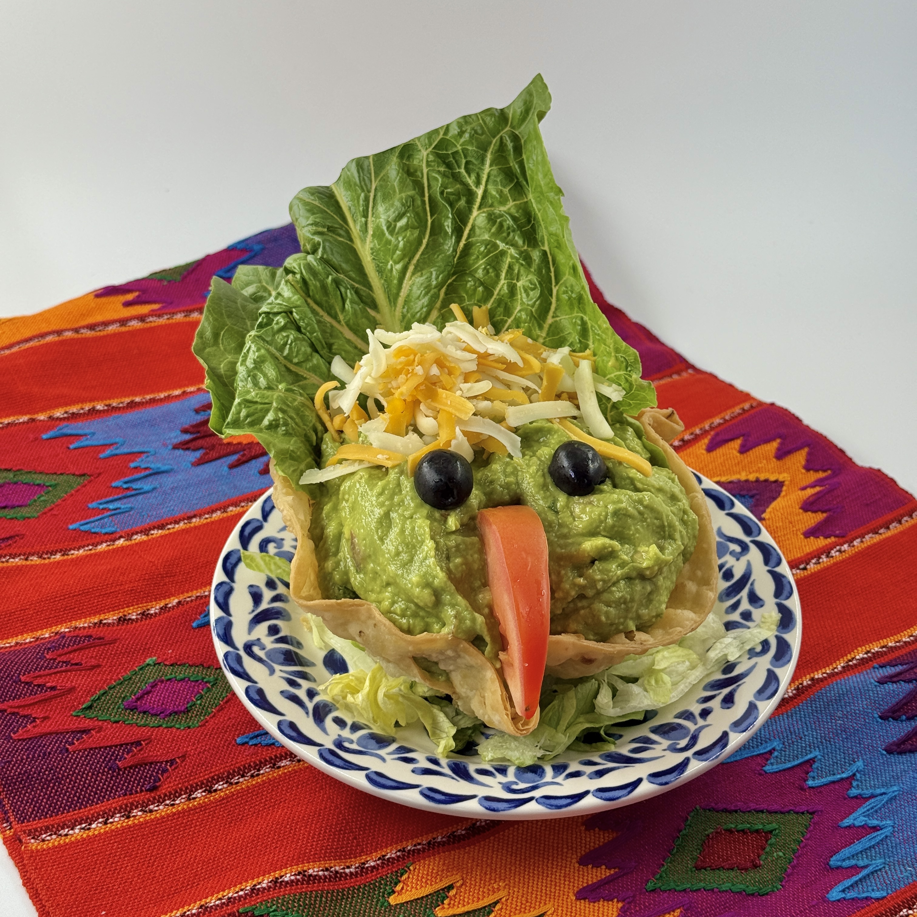 Concha de Guacamole at Casa de Pico: housemade guacamole in a crisp flour shell topped with shredded cheese, on a blue-and-white plate