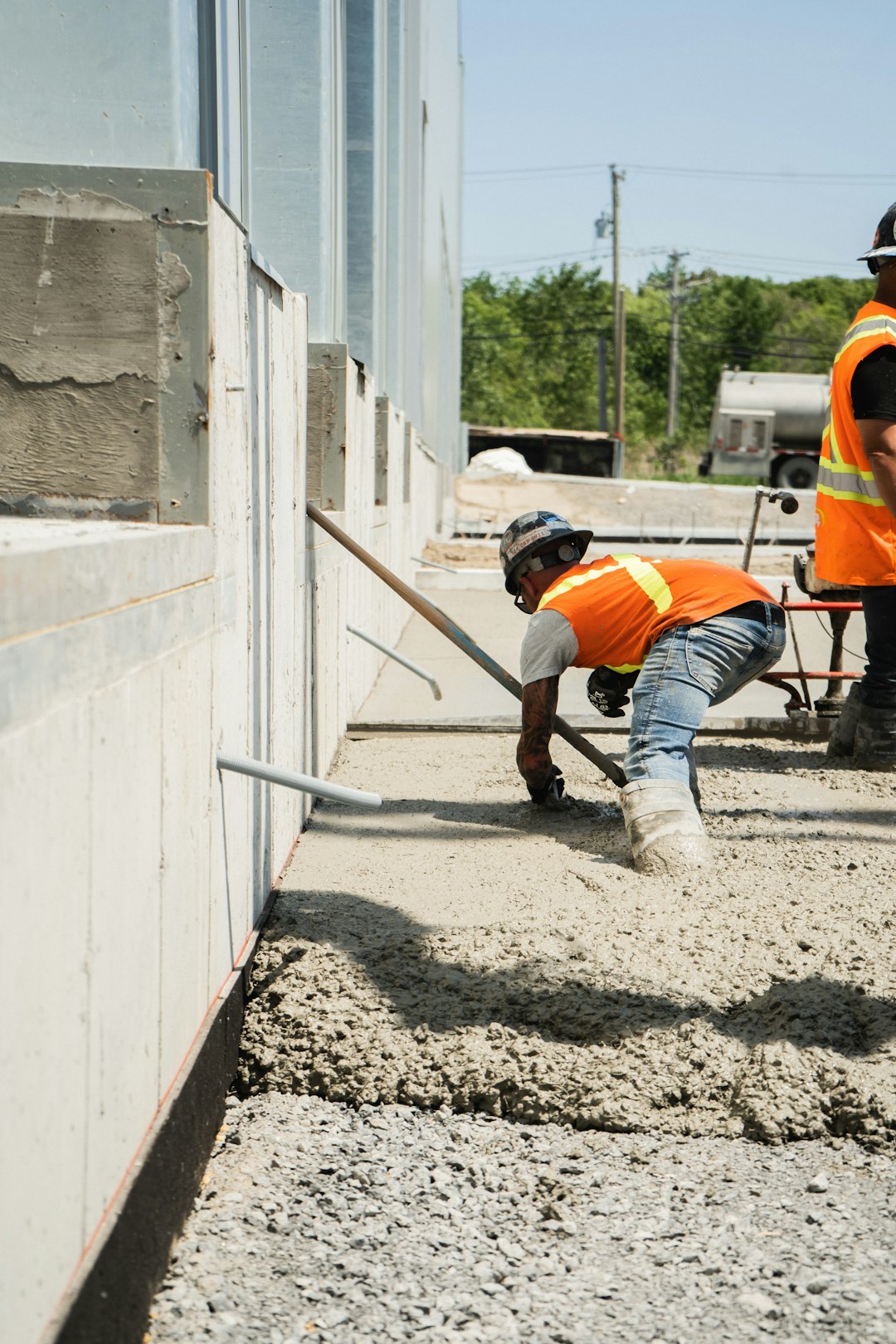 A foundation crew finishing concrete along a home