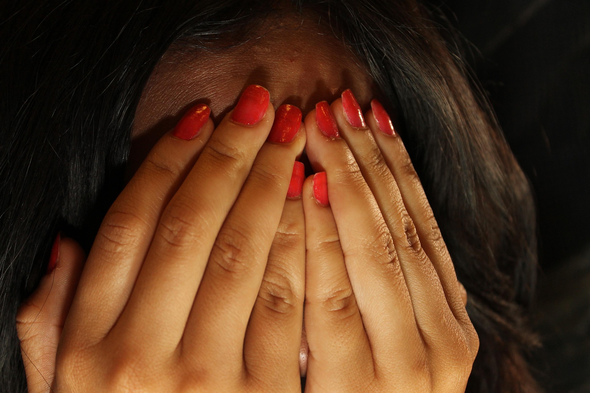 Woman with face covered by hands