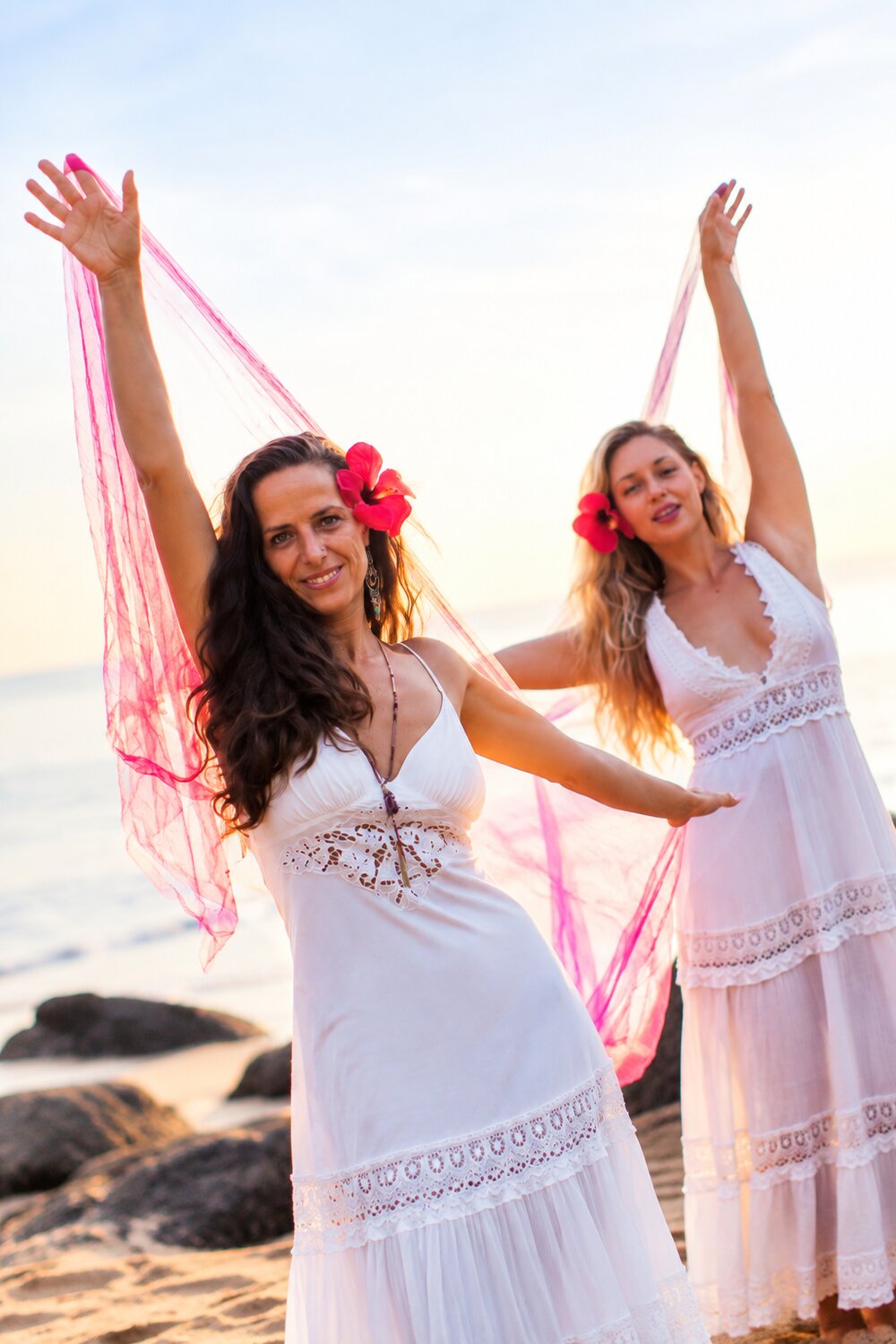Women dancing freely beneath the Bali sunset