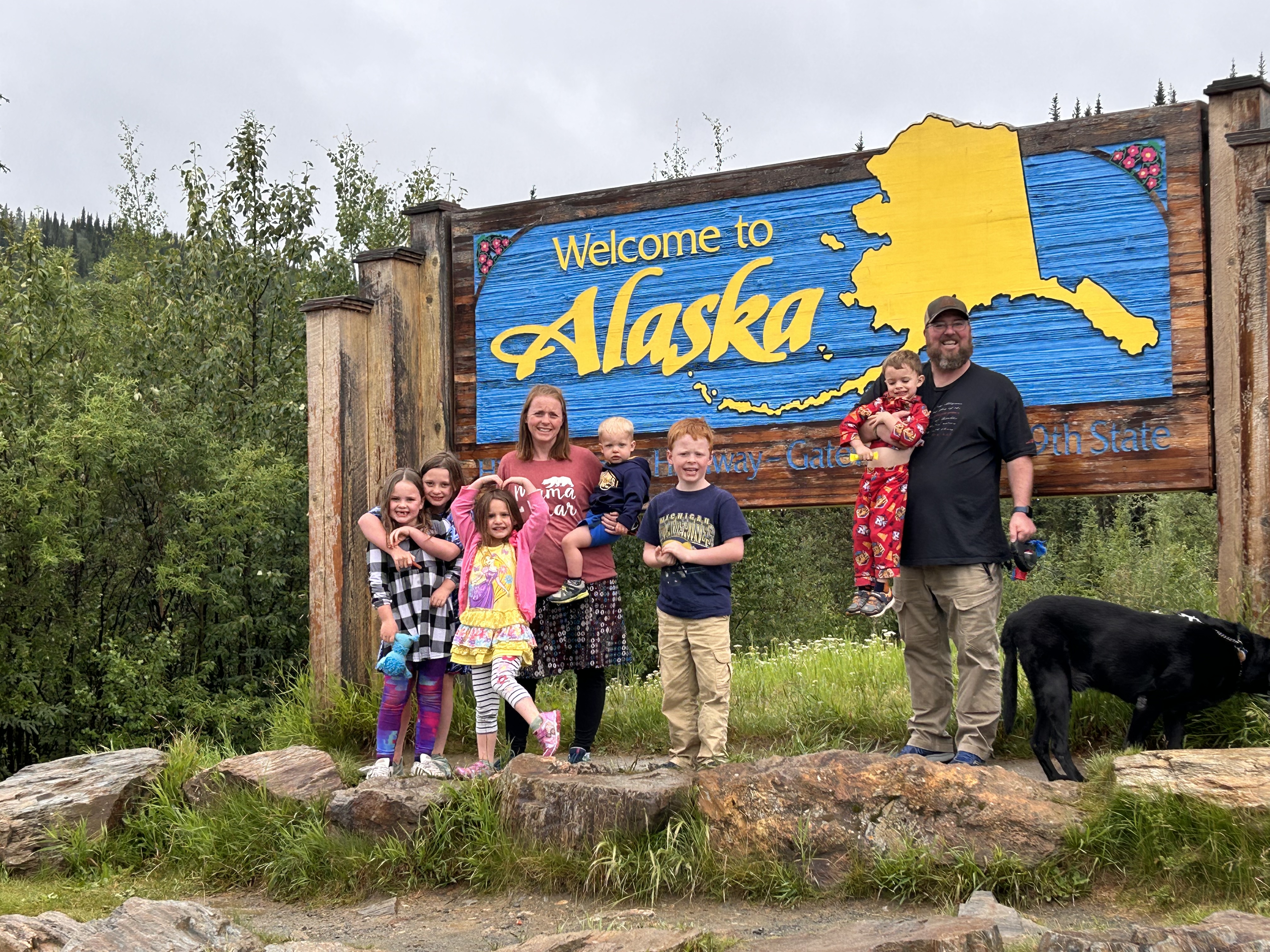 Welcome to Alaska sign, family and dog