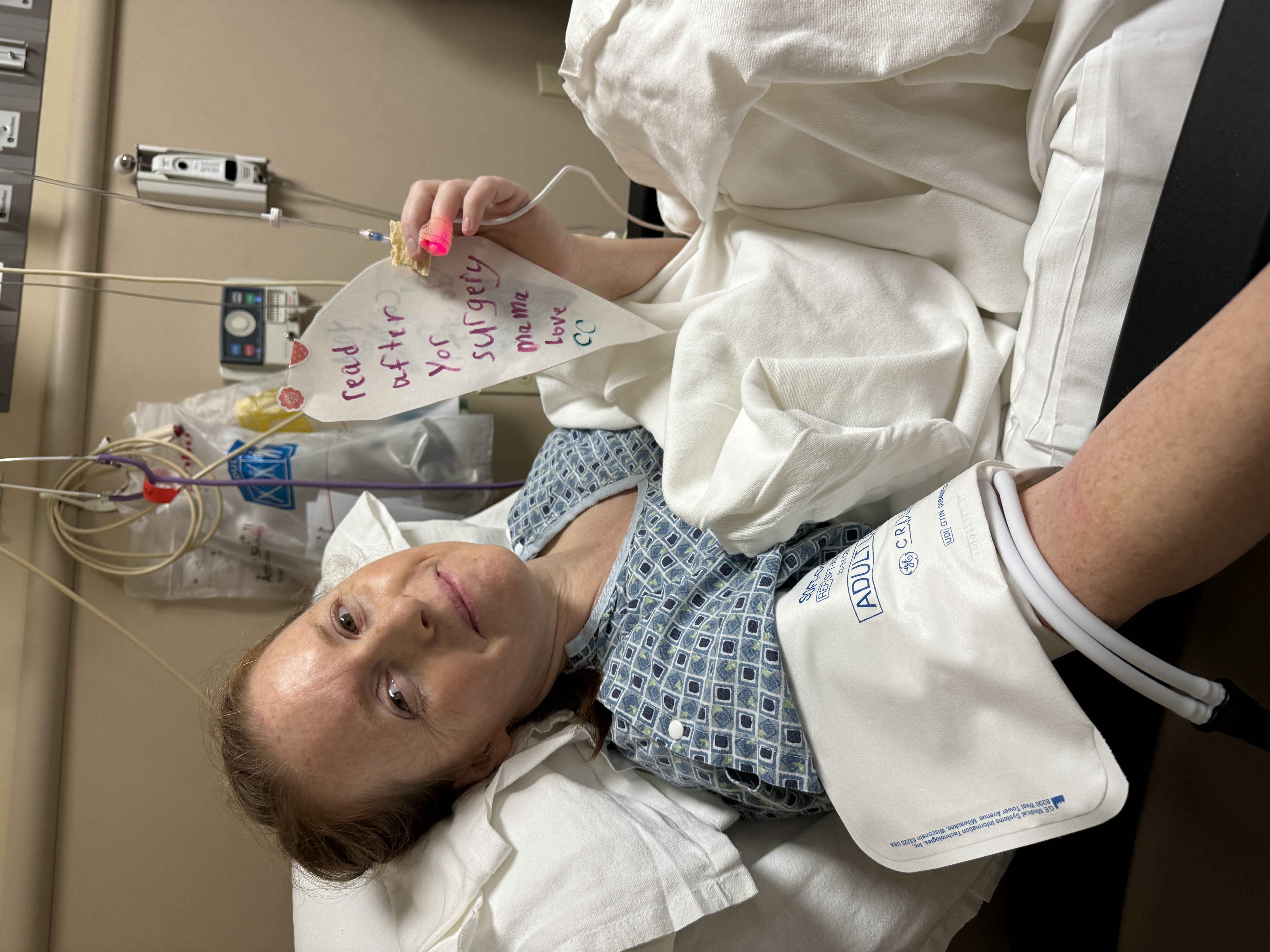 Brooke in the hospital bed holding her daughter's note