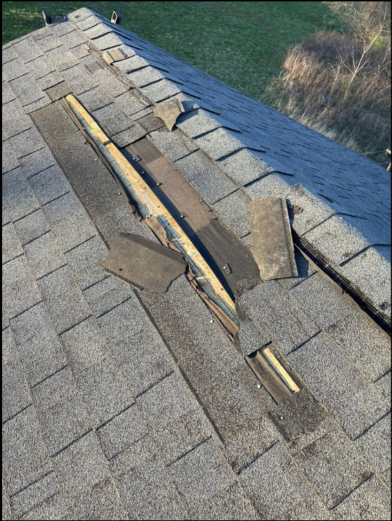 Wind damaged shingles on a residential home from a recent wind storm. Wind damaged shingles on a residential home from a recent wind storm.