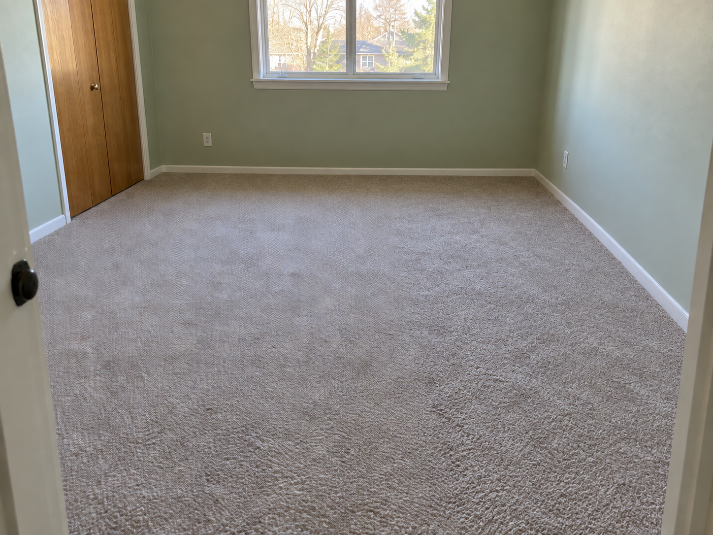 After: the same bedroom with the carpet re-installed flat and tight to every wall