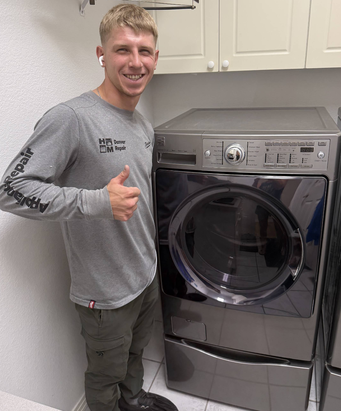 Gena beside a washing machine he just repaired — Denver metro