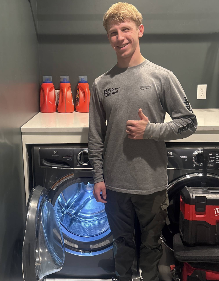 Gena giving a thumbs-up beside a repaired washing machine — Denver metro