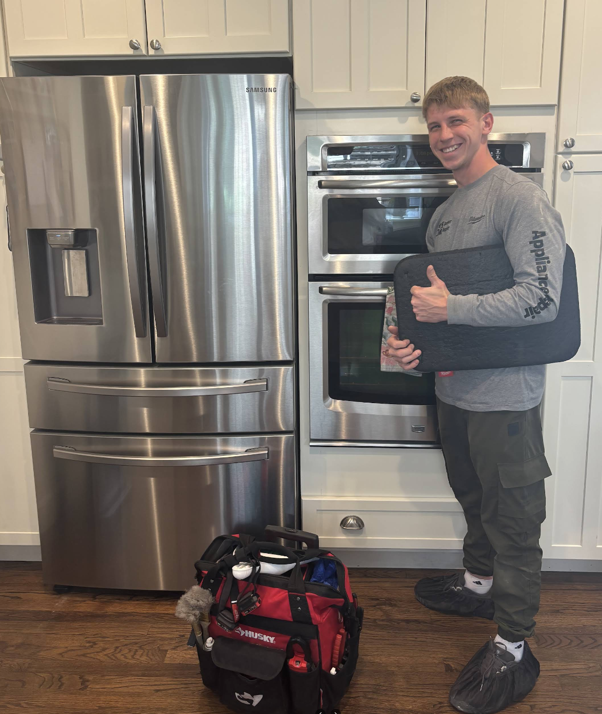 Gena with his tools and laptop in front of a Samsung refrigerator and oven — Denver metro