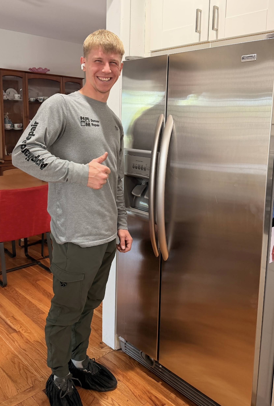 Gena in front of a stainless steel refrigerator he serviced — Denver metro