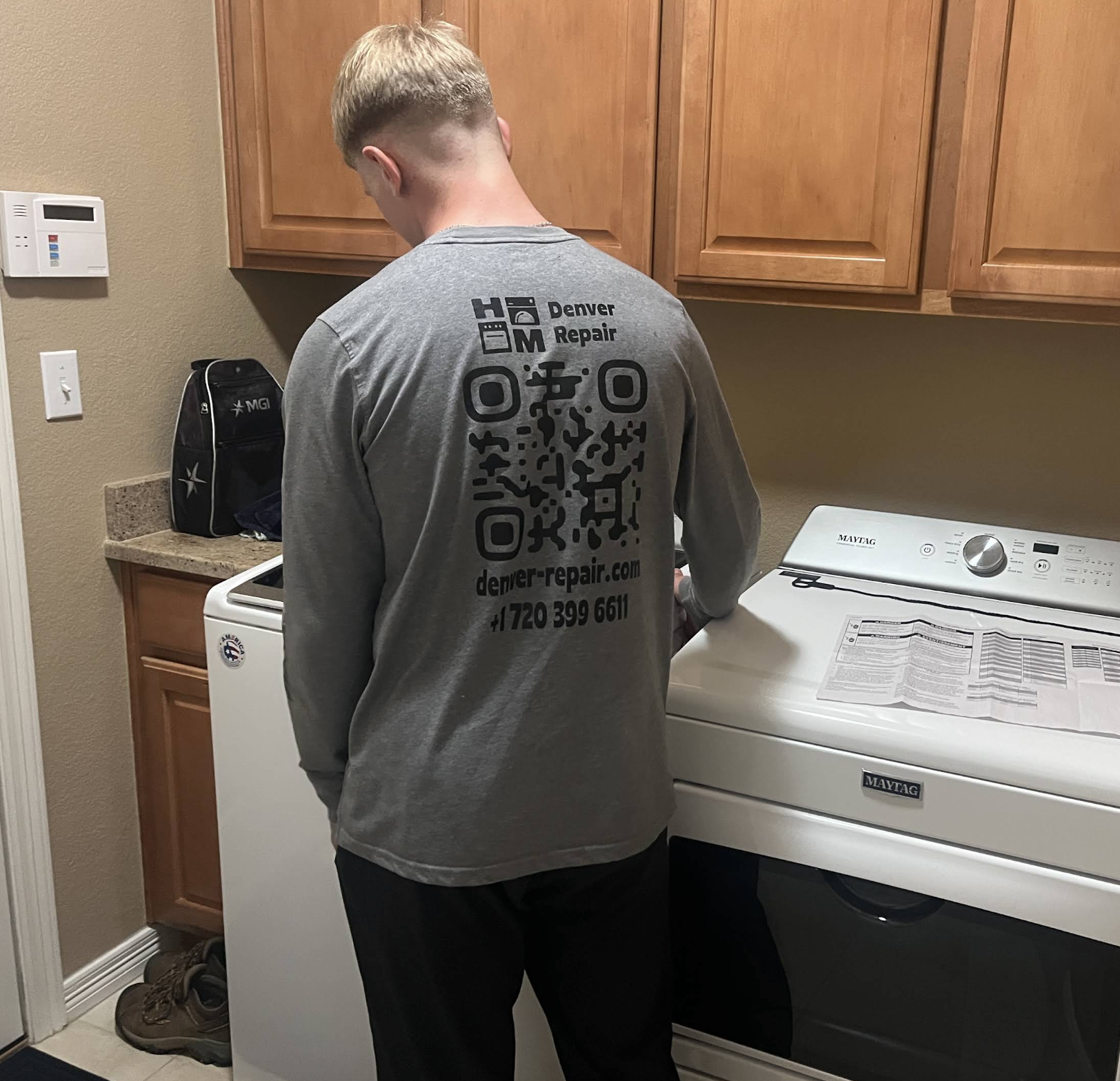Gena beside a washer during a service call — Denver metro