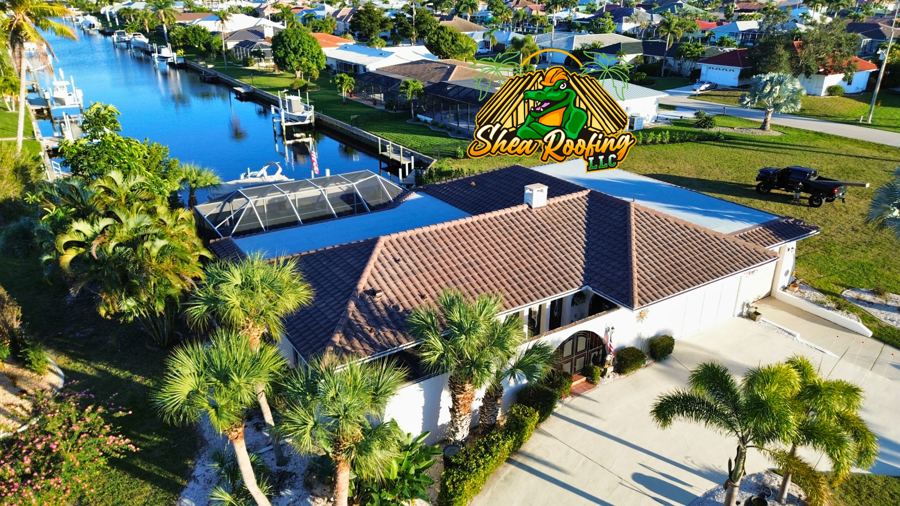 Aerial view of a tile roof by Shea Roofing on a canal home with palms