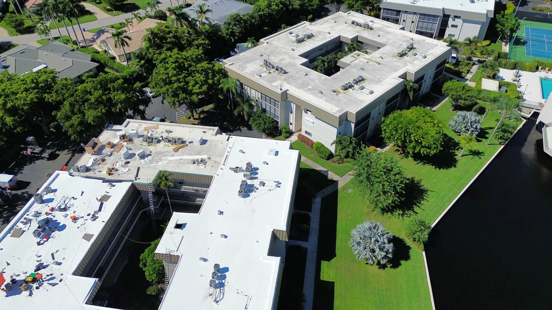 Two condominium wings with white TPO roofs seen from above