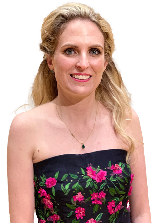Portrait of Dr. Megan A. Ratliff smiling, with long, wavy blonde hair, wearing a strapless black dress with pink floral embroidery, symbolizing the friendly and professional image of the dental care provider.