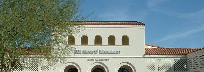 White stucco facade and arched windows of the Heard Museum in Phoenix.