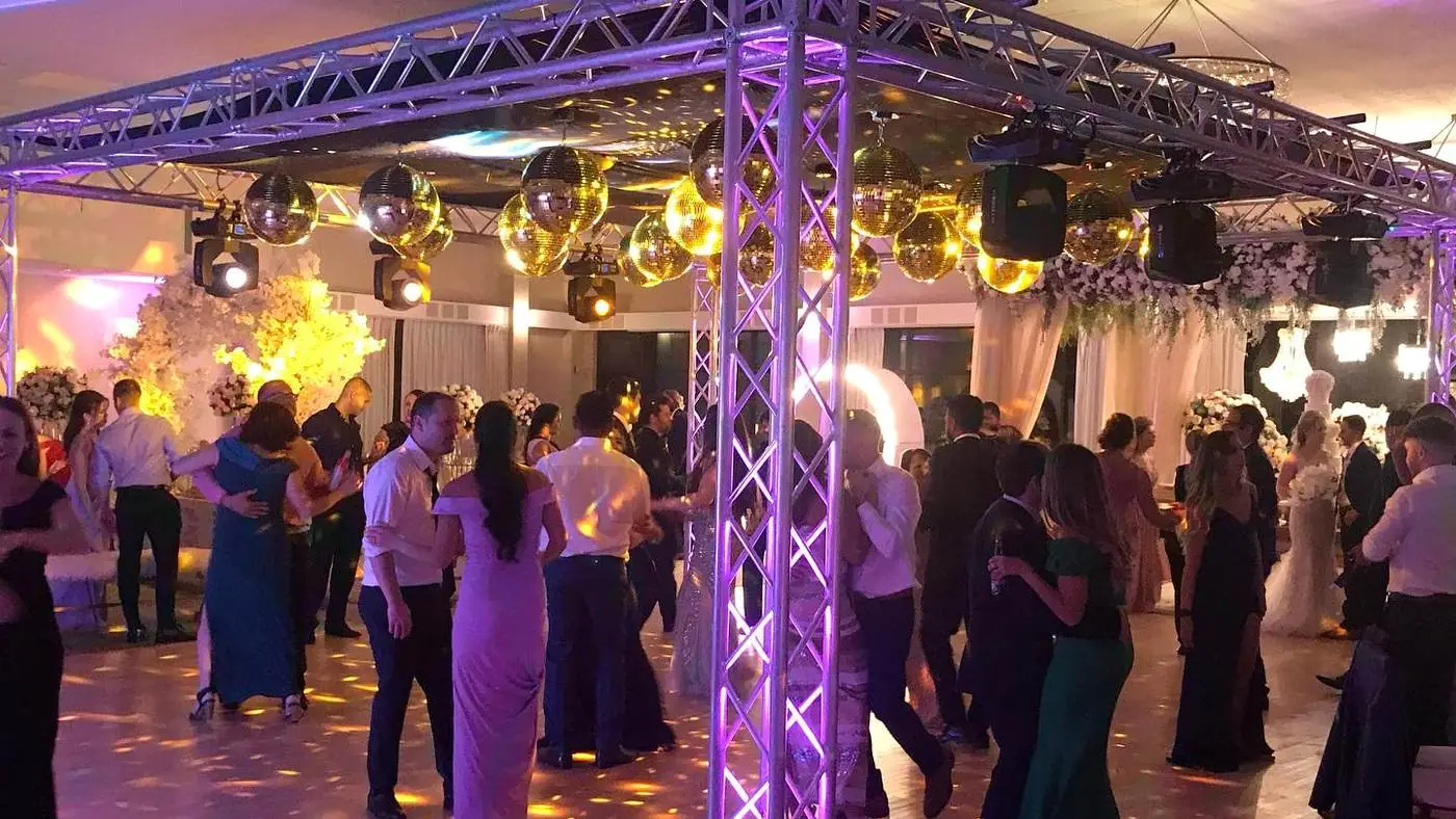 Full dance floor at a wedding with truss, mirror balls and uplighting