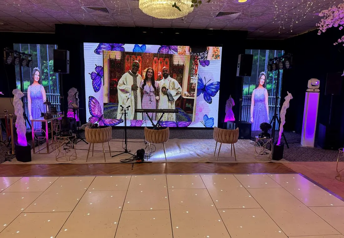 DJ booth with LED screen and illuminated dance floor at a celebration