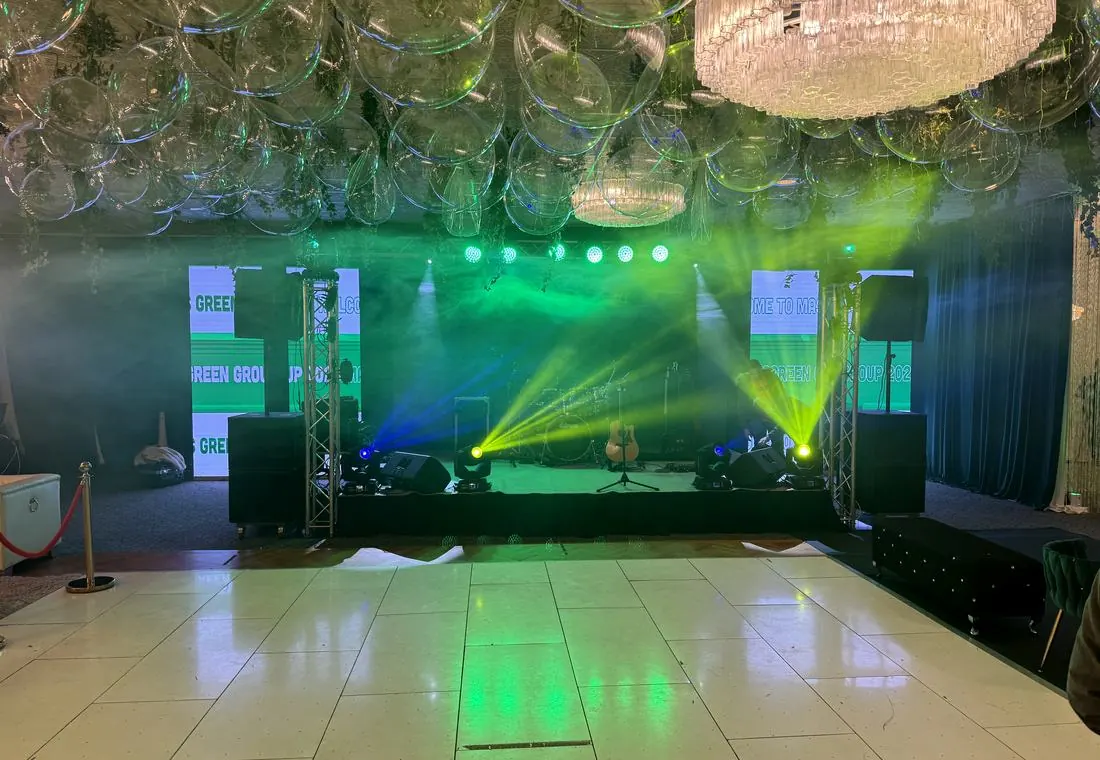 Stage with PA system, monitors and beam lighting at a corporate event
