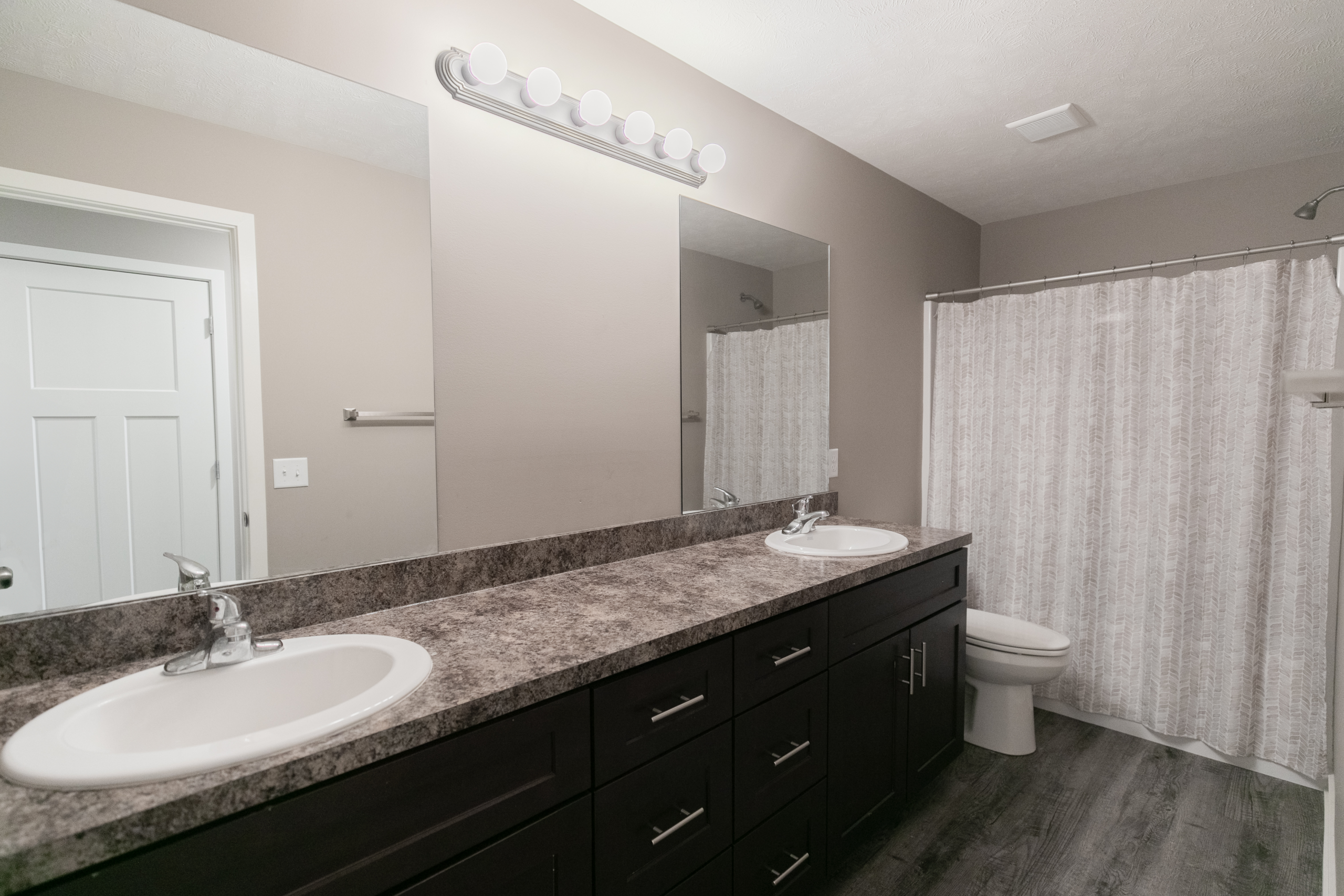 Main bathroom with double vanity and granite