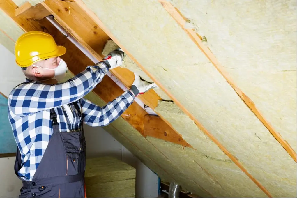 Worker removing old attic insulation during retrofit project by 903 Spray Foam in Sumner, TX